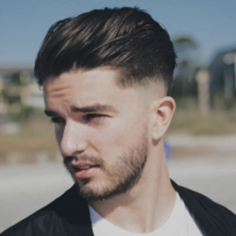 Mężczyzna z fade'em i krótką brodą, portret na świeżym powietrzu