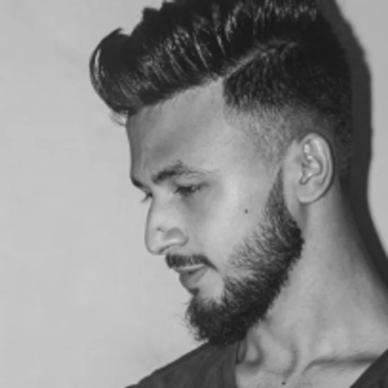 Czarno-białe zdjęcie mężczyzny z brodą i zaczesaną fryzurą, widok z profilu