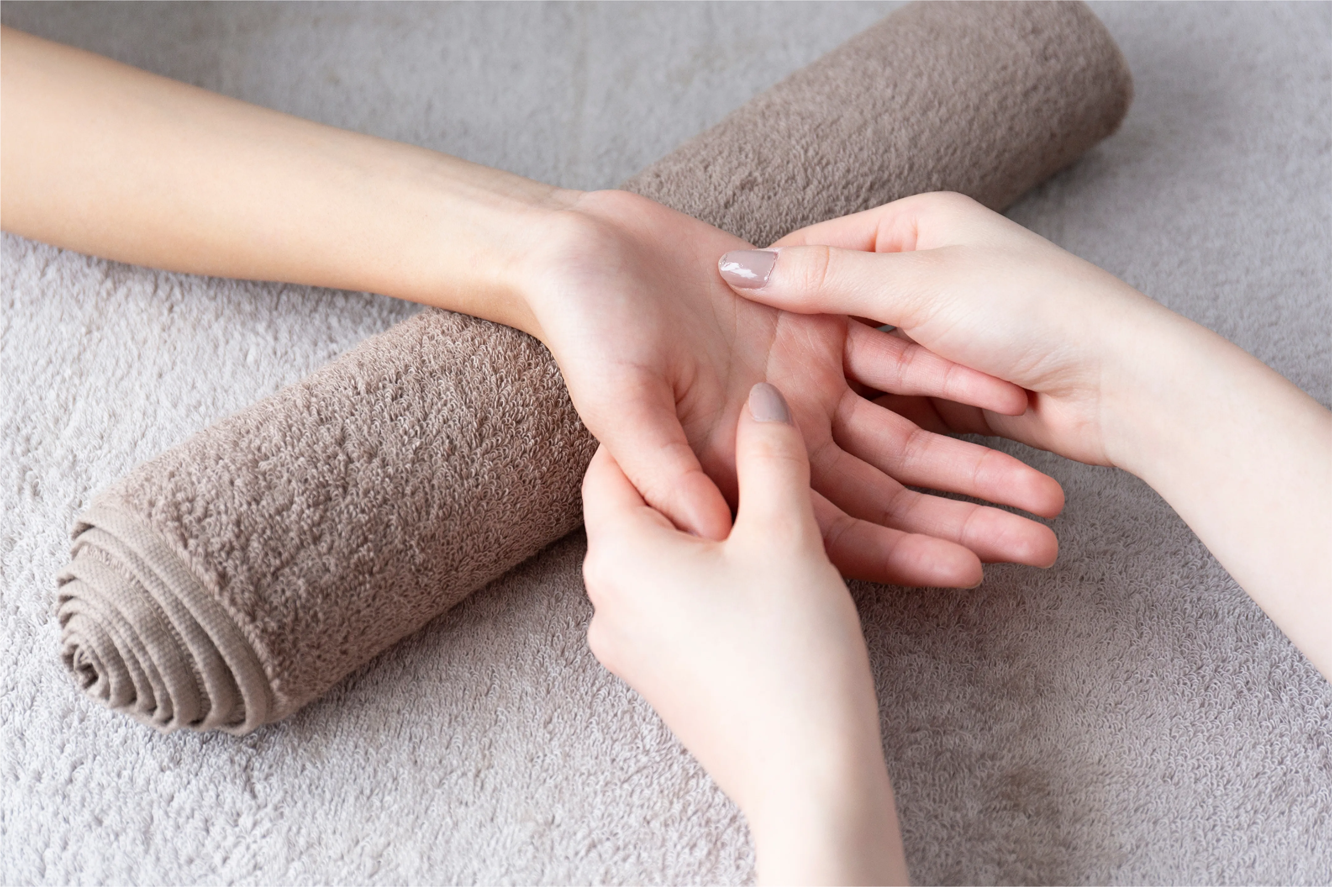 Childs hand on a treatment table with a towel