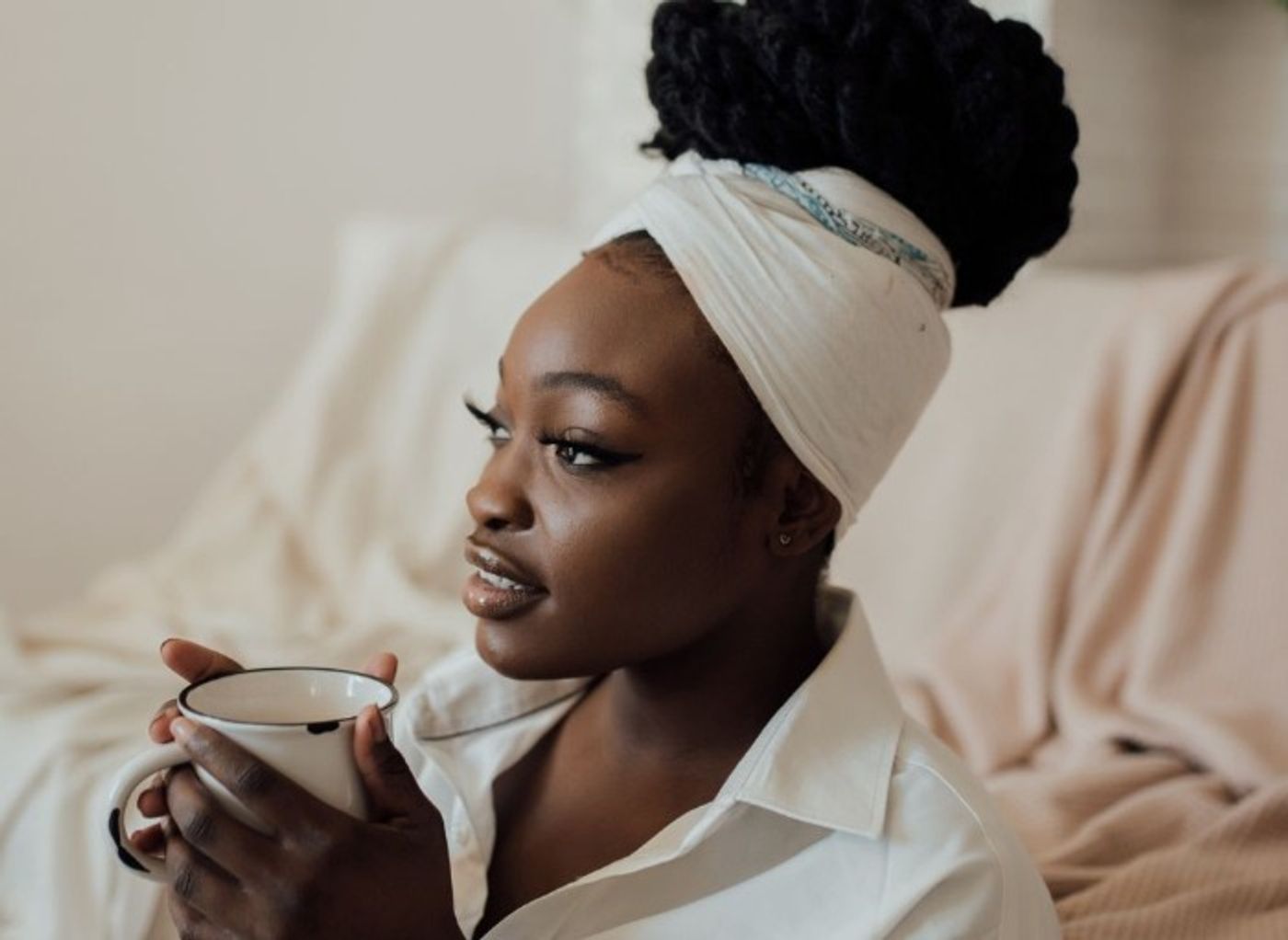 Woman holding hot drink and reflecting