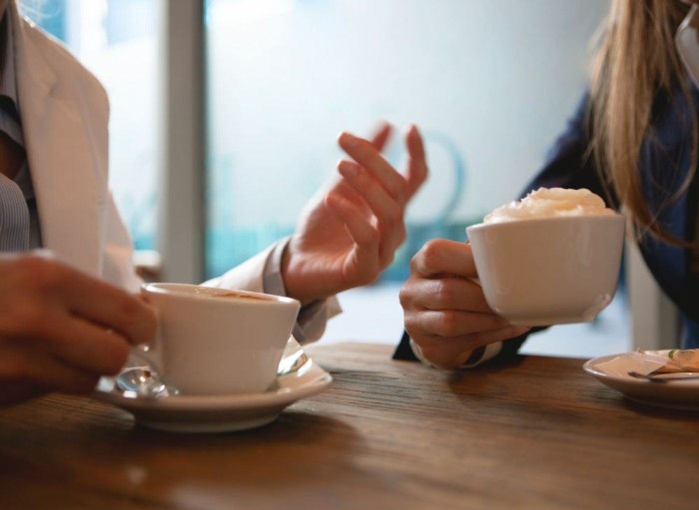 two women having a conversation over coffee