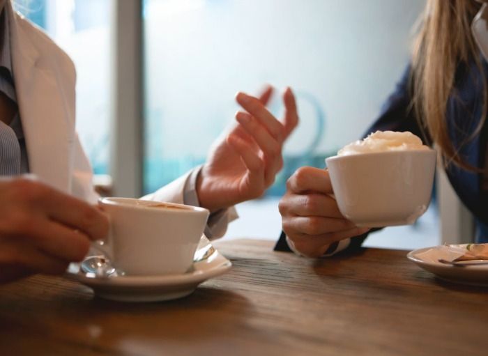 two women having a conversation over coffee