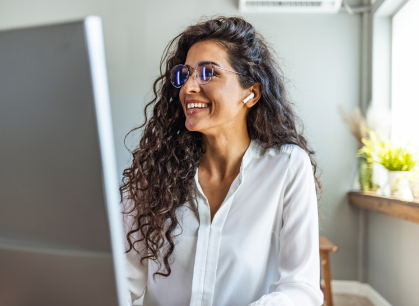 woman working on computer smiling with headphones