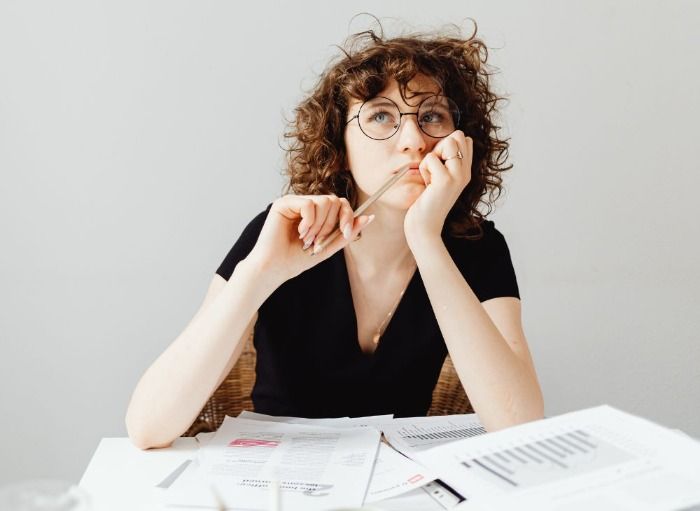 Woman with pencil thinking