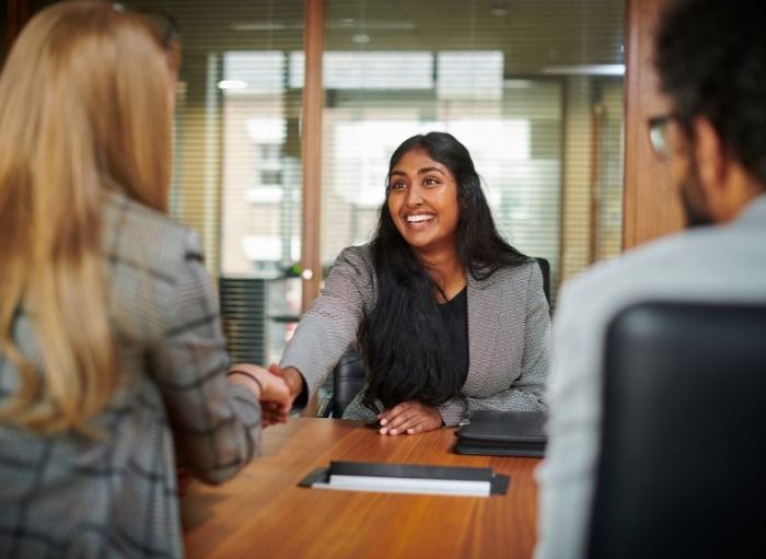sucessful female candidate shaking hands at job interview