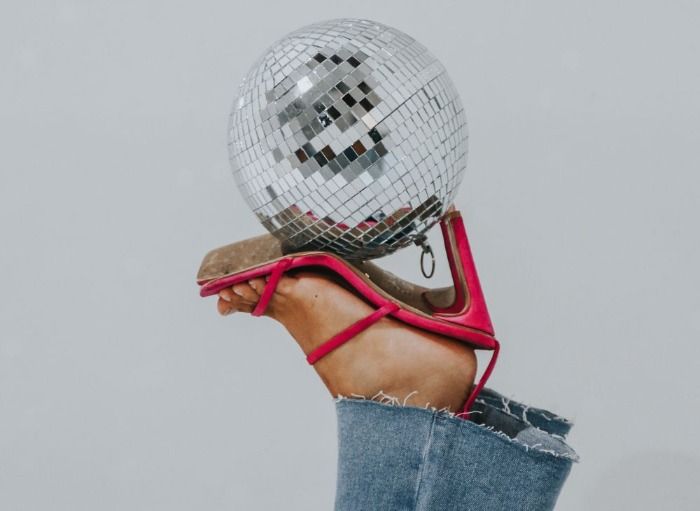 red high heels holding up disco ball
