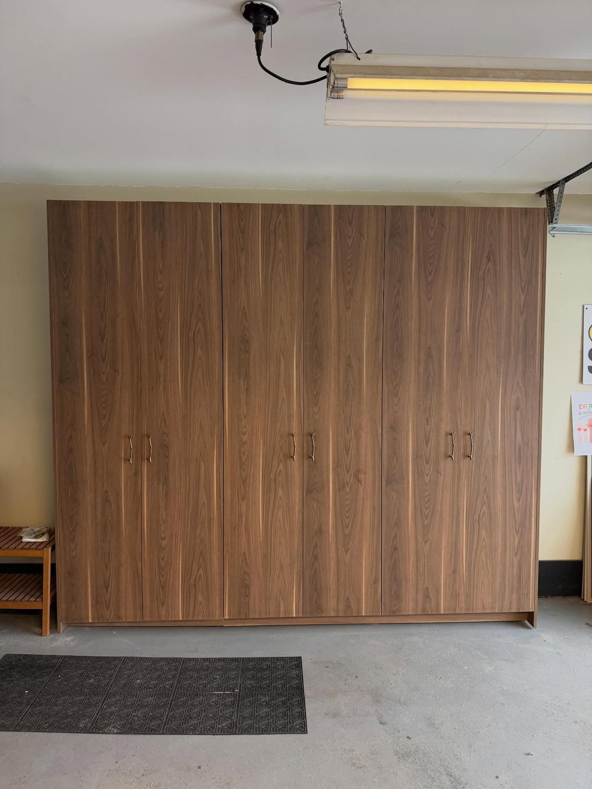 Wall of tall garage cabinets in a warm walnut-look finish