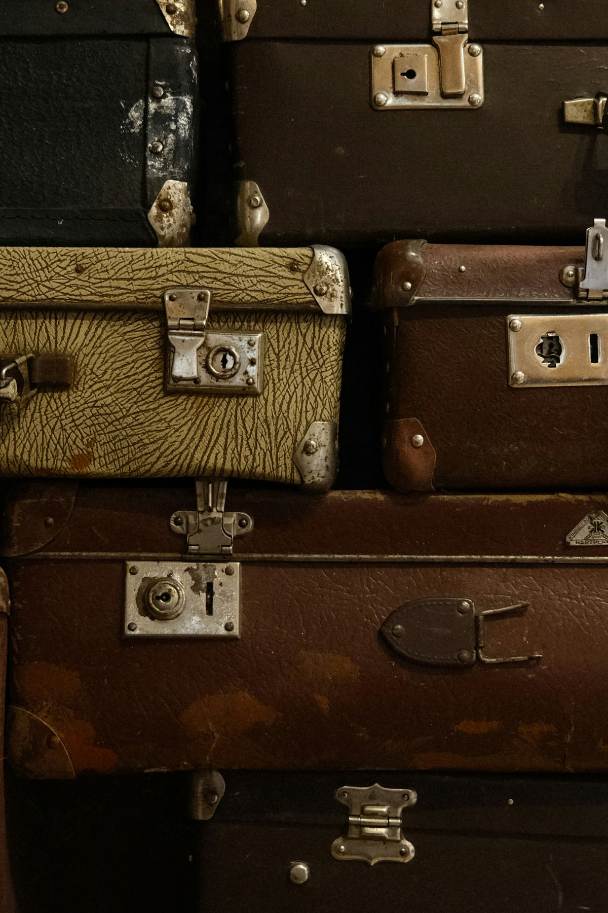A stack of vintage and old suitcases