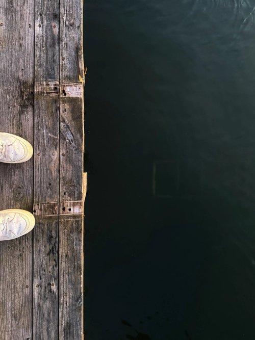 Feet on rock looking down at ladder at the bottom of the river