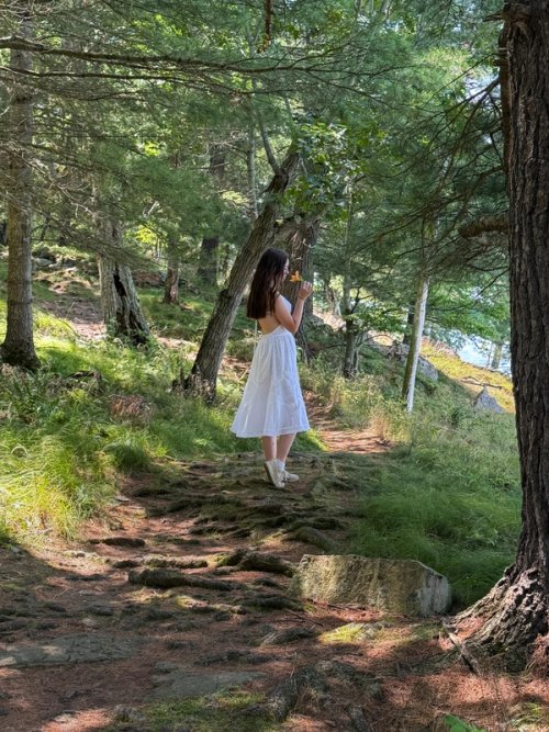 Girl in forest trail smelling a tiger lily