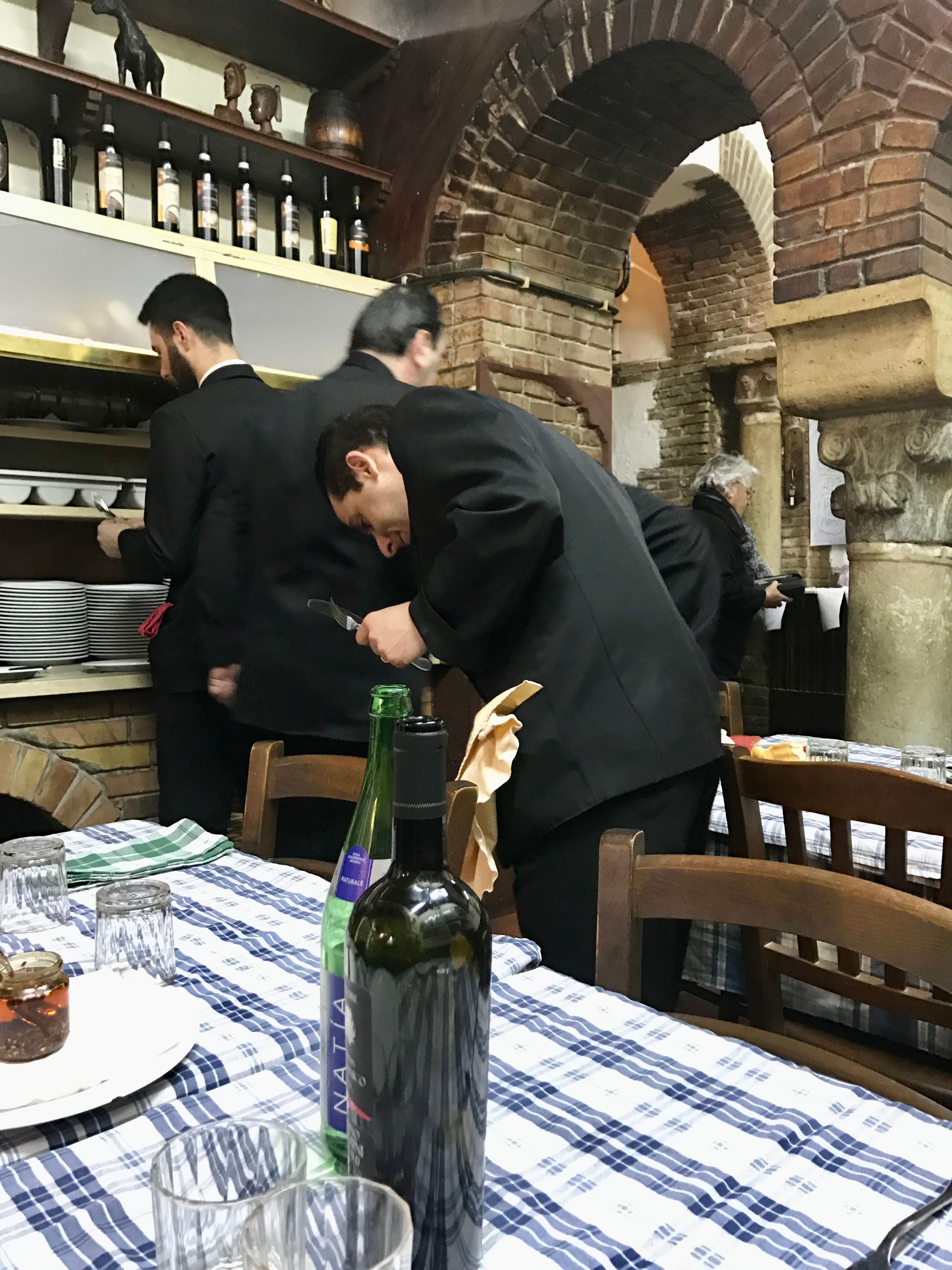 Table setting and waiters in Italian restaurant