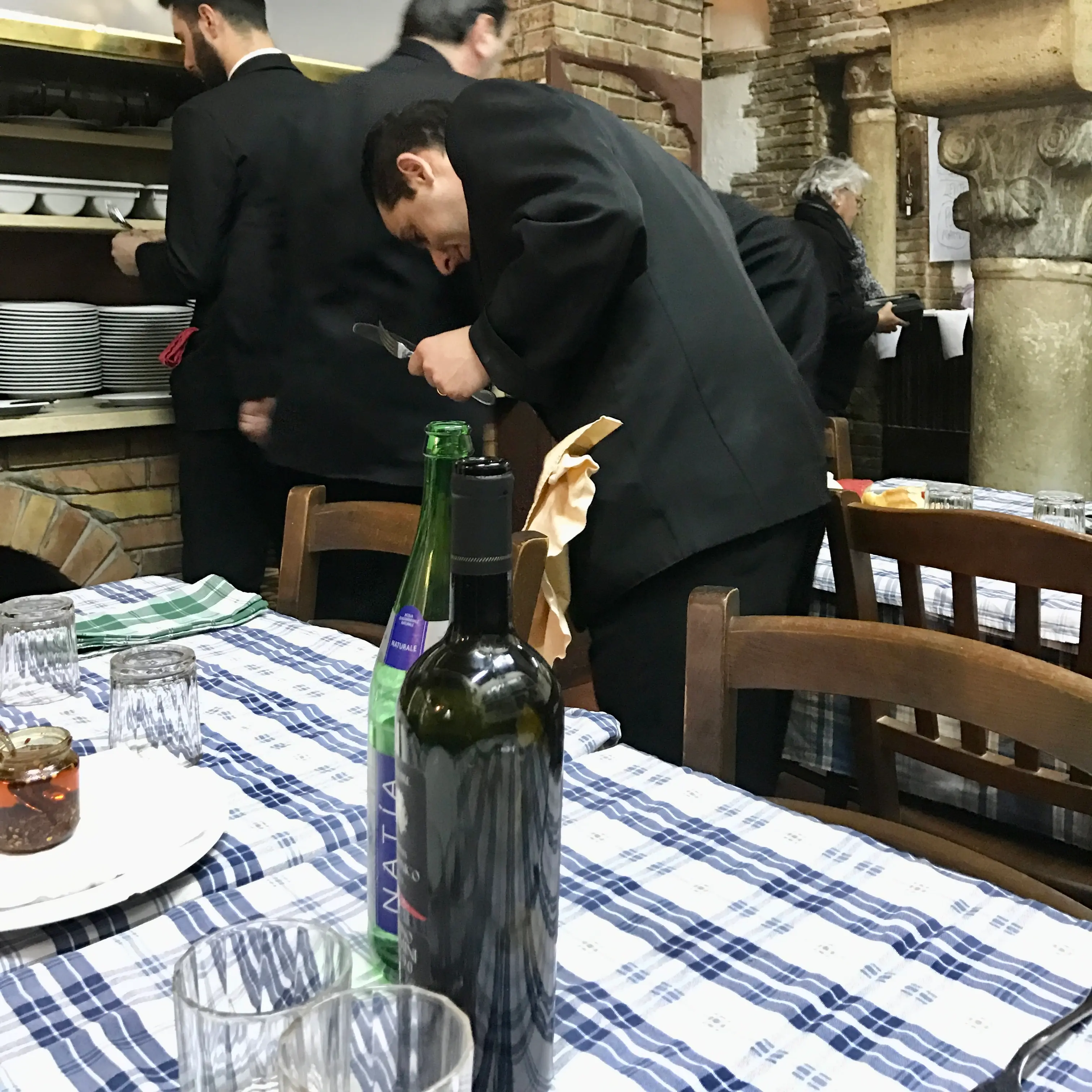Table setting and waiters in Italian restaurant