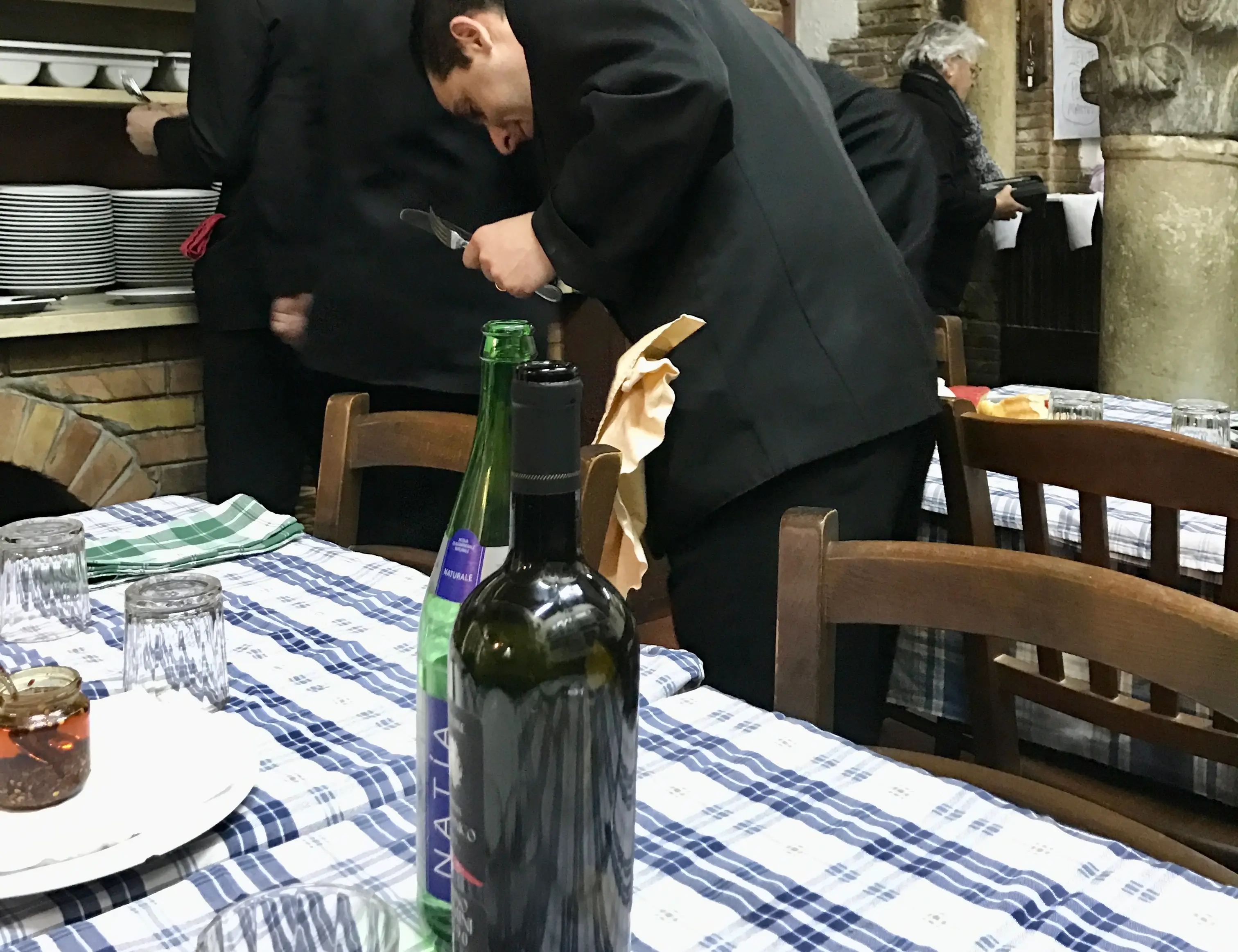 Table setting and waiters in Italian restaurant
