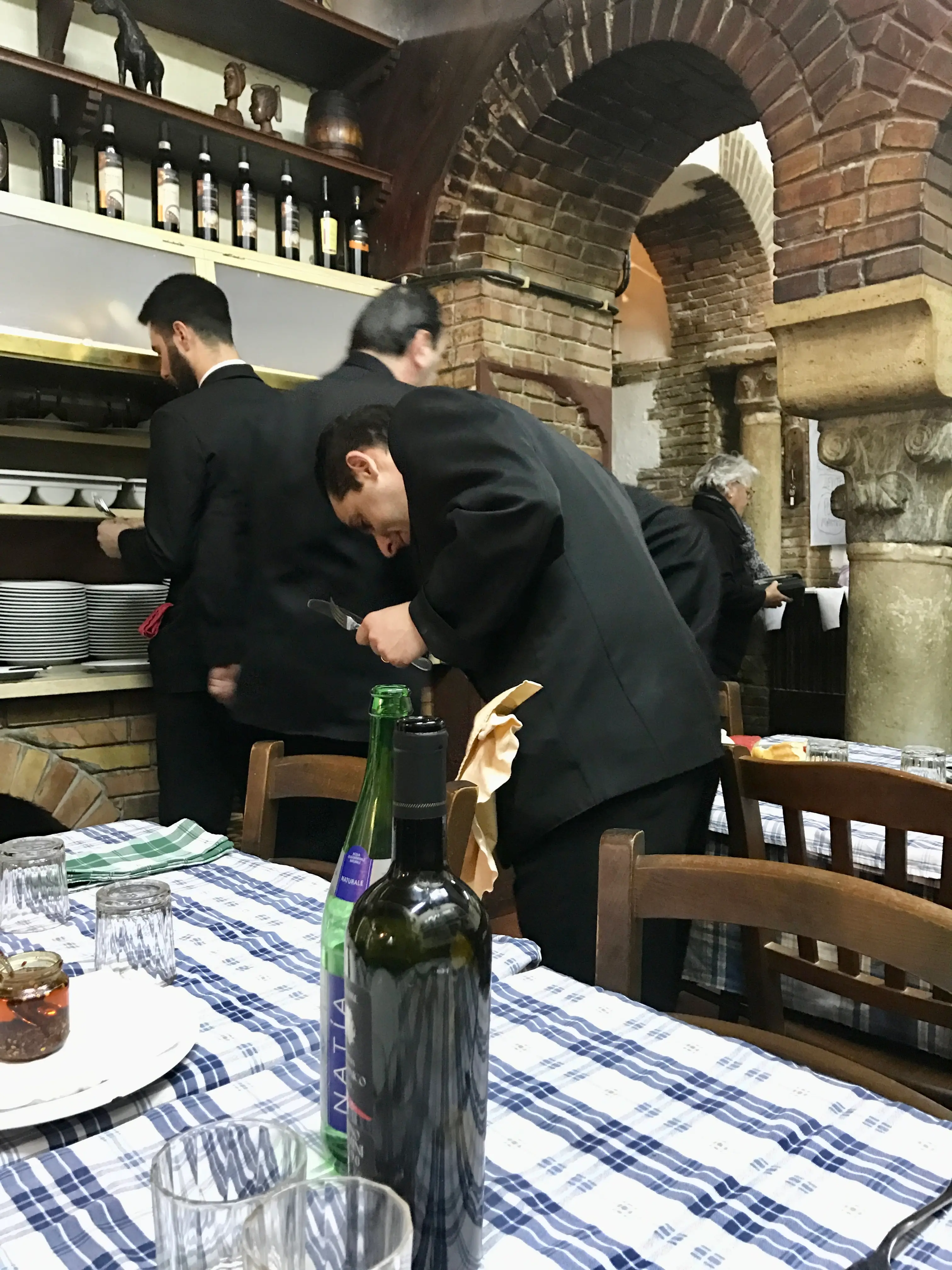Table setting and waiters in Italian restaurant