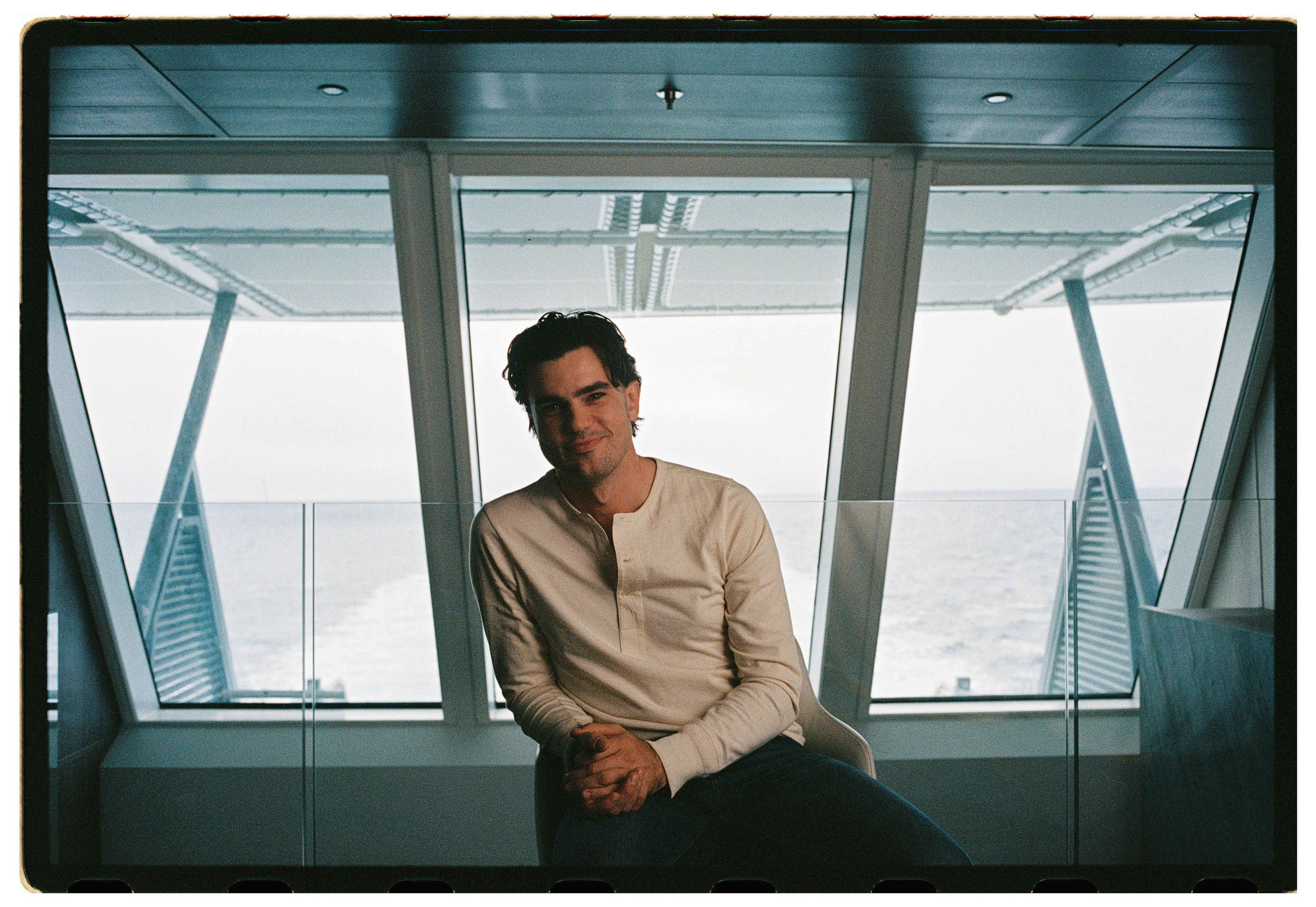 Alex Hillary leaning against a window with a view of the Artic