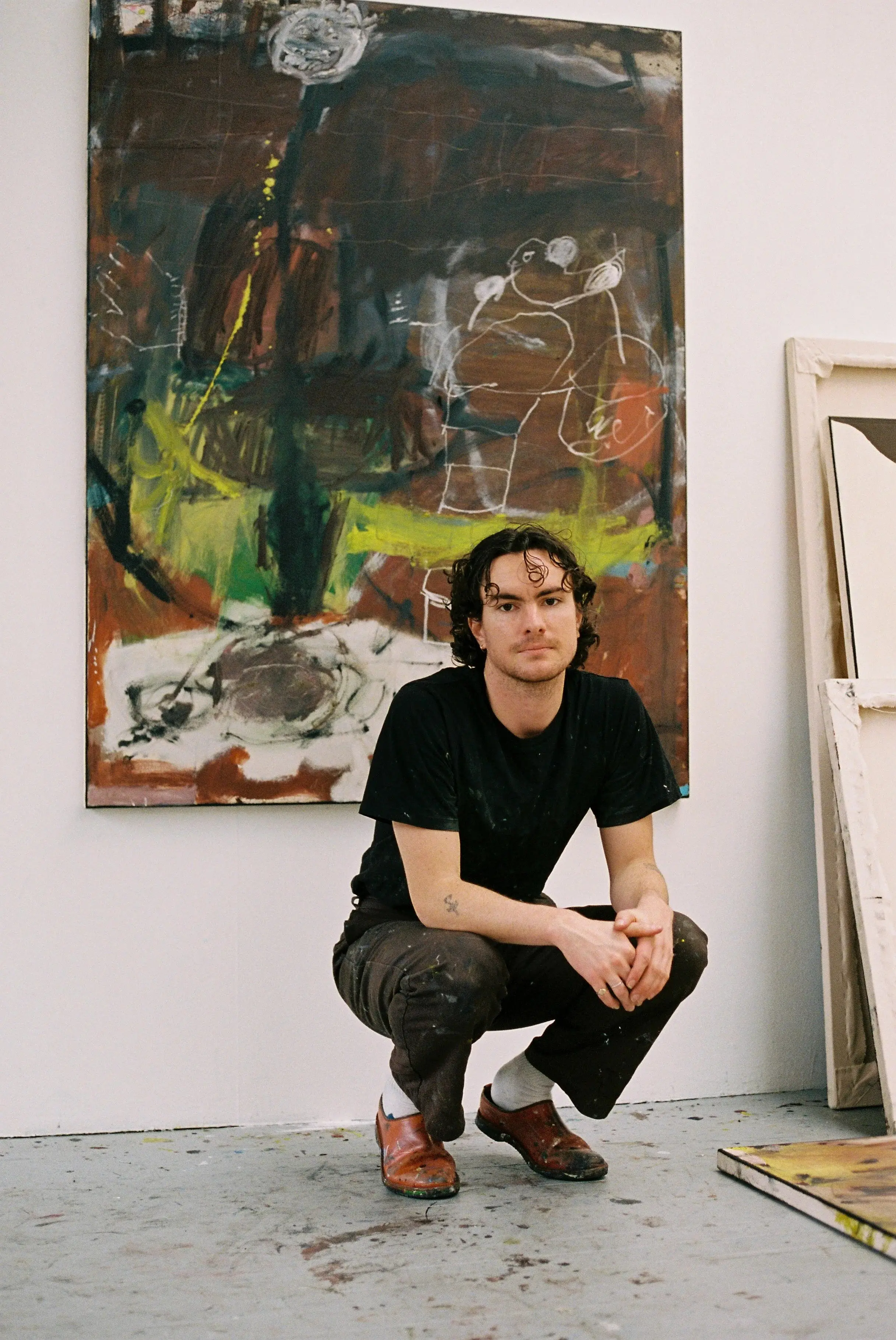 artist christian dimick kneeling infront of painting
