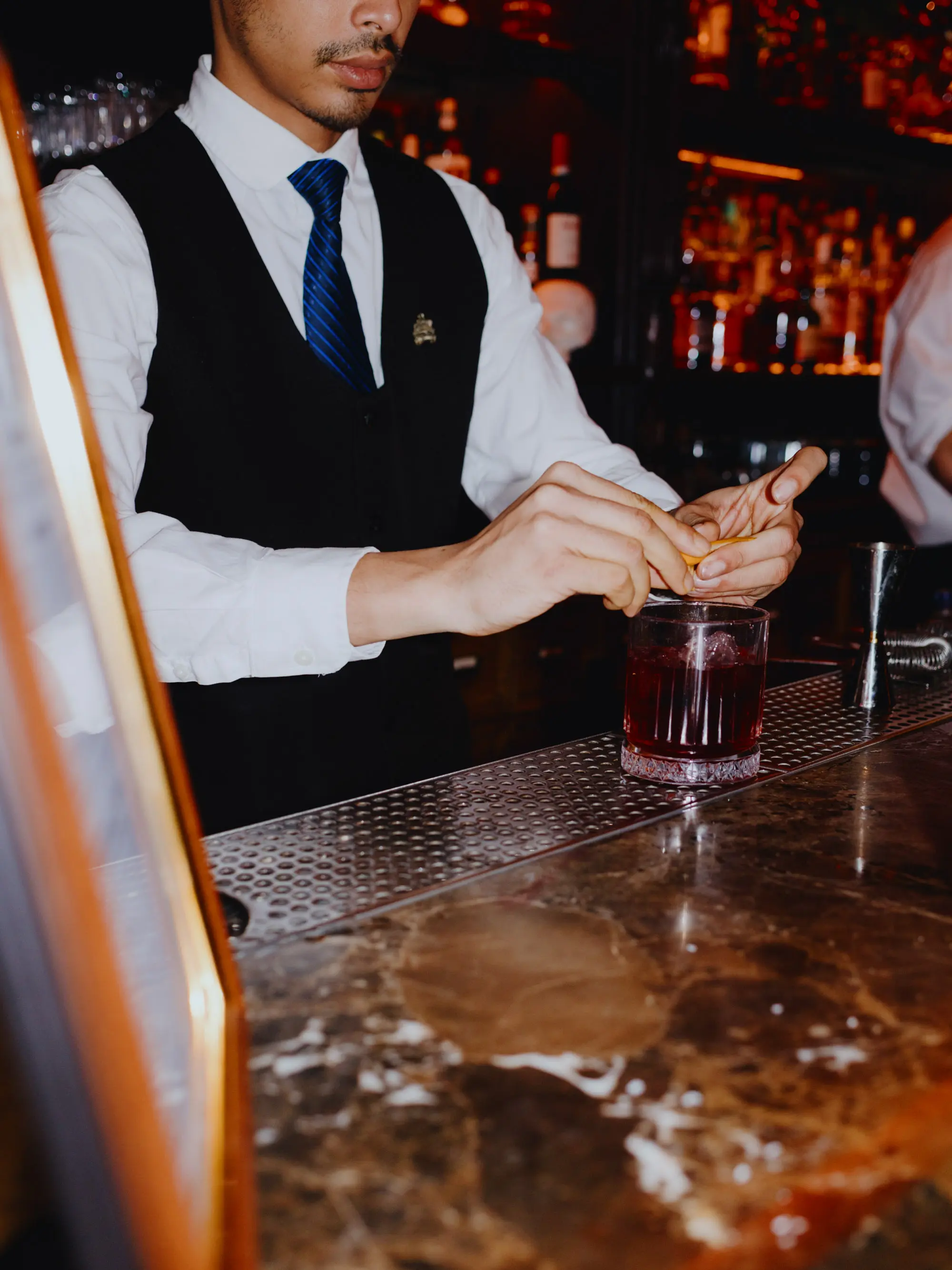 Barman squeezing lemon into a cocktail