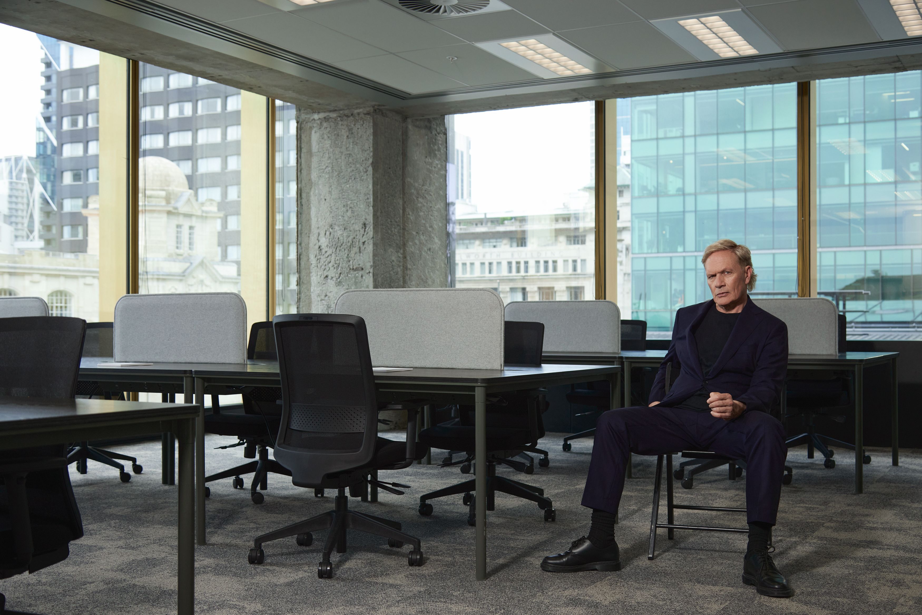 Shayne Carter Sitting on Chair in empty office space