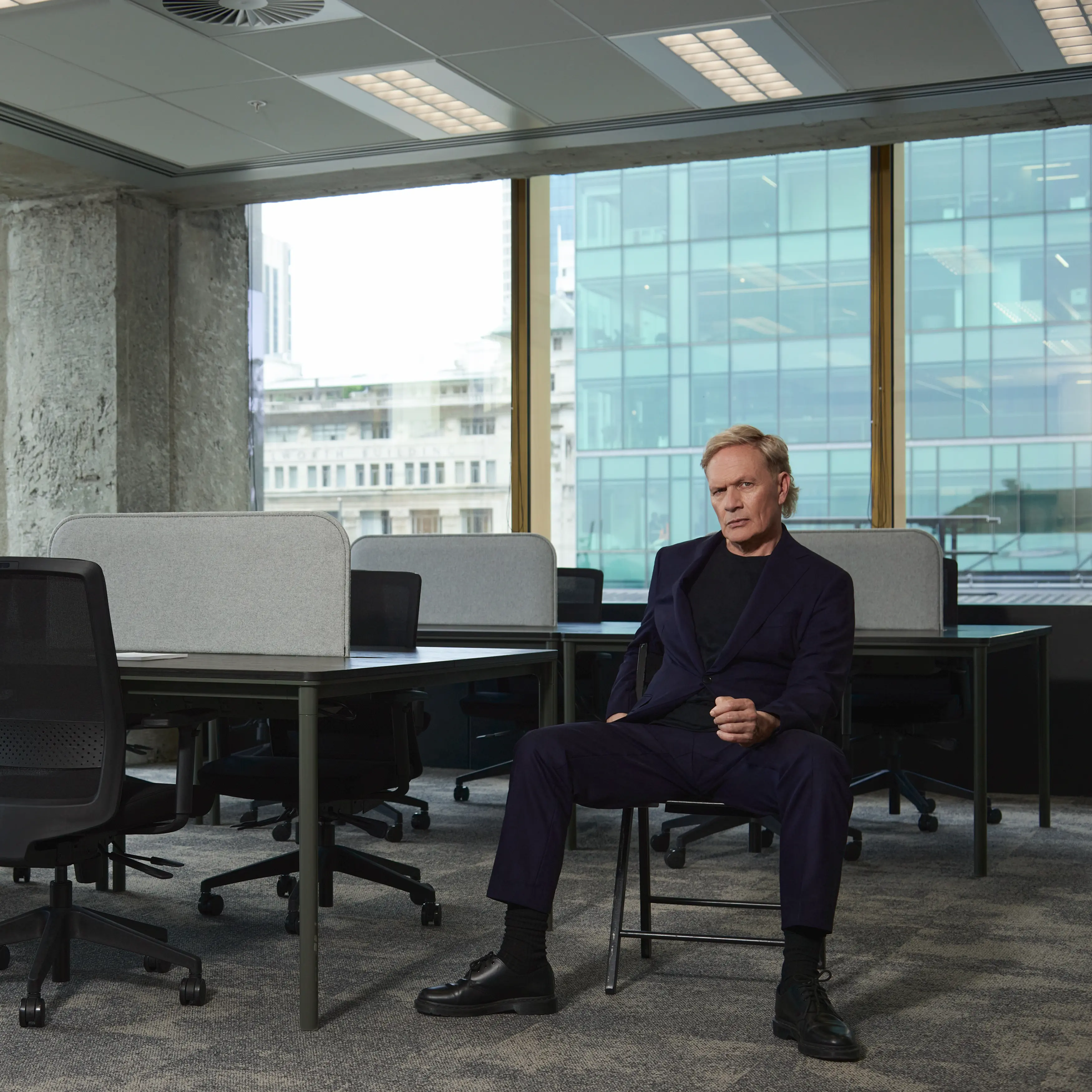 Shayne Carter Sitting on Chair in empty office space