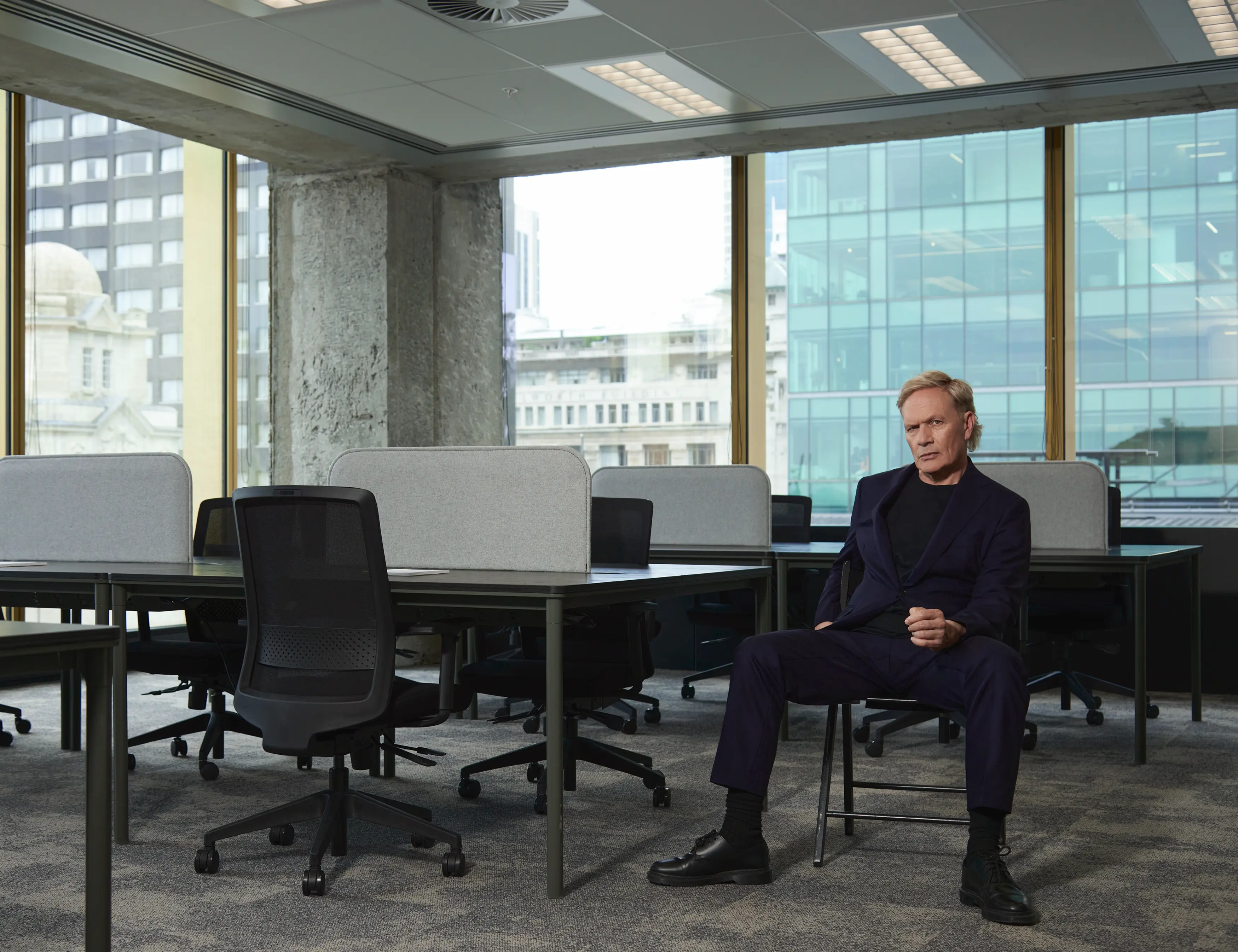 Shayne Carter Sitting on Chair in empty office space