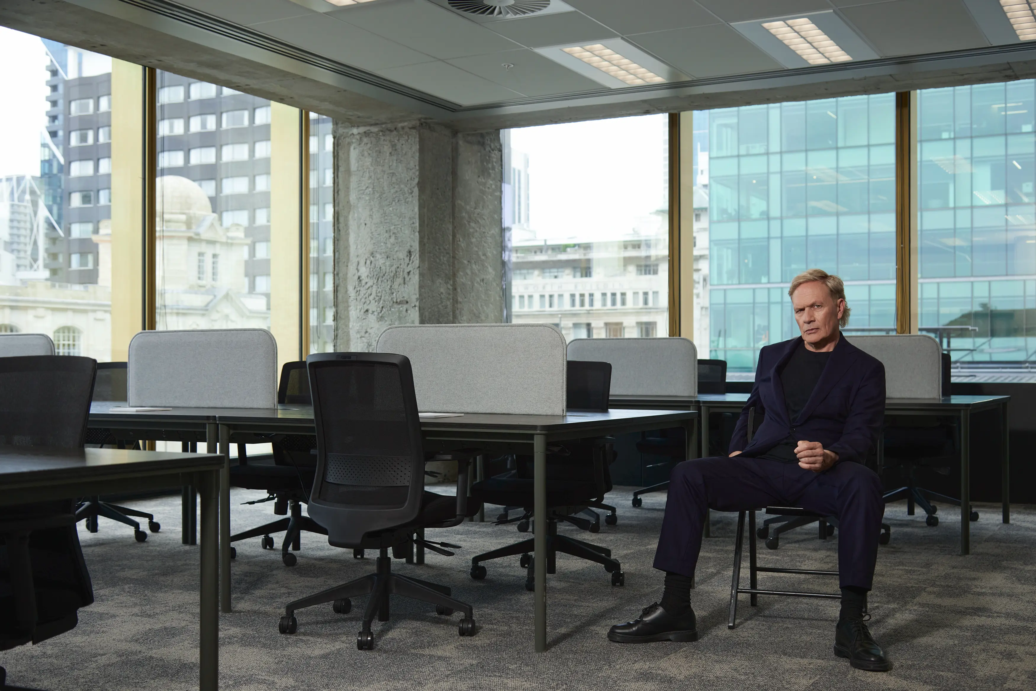 Shayne Carter Sitting on Chair in empty office space