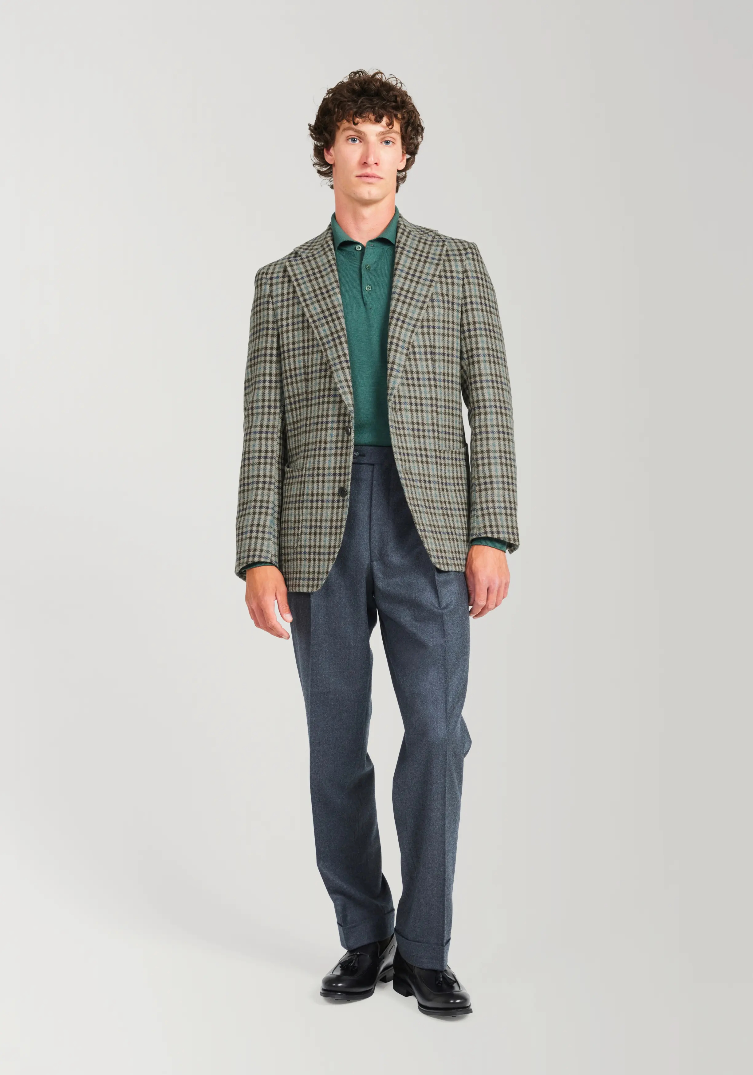 Man in Tweed jacket and grey trousers on light grey background