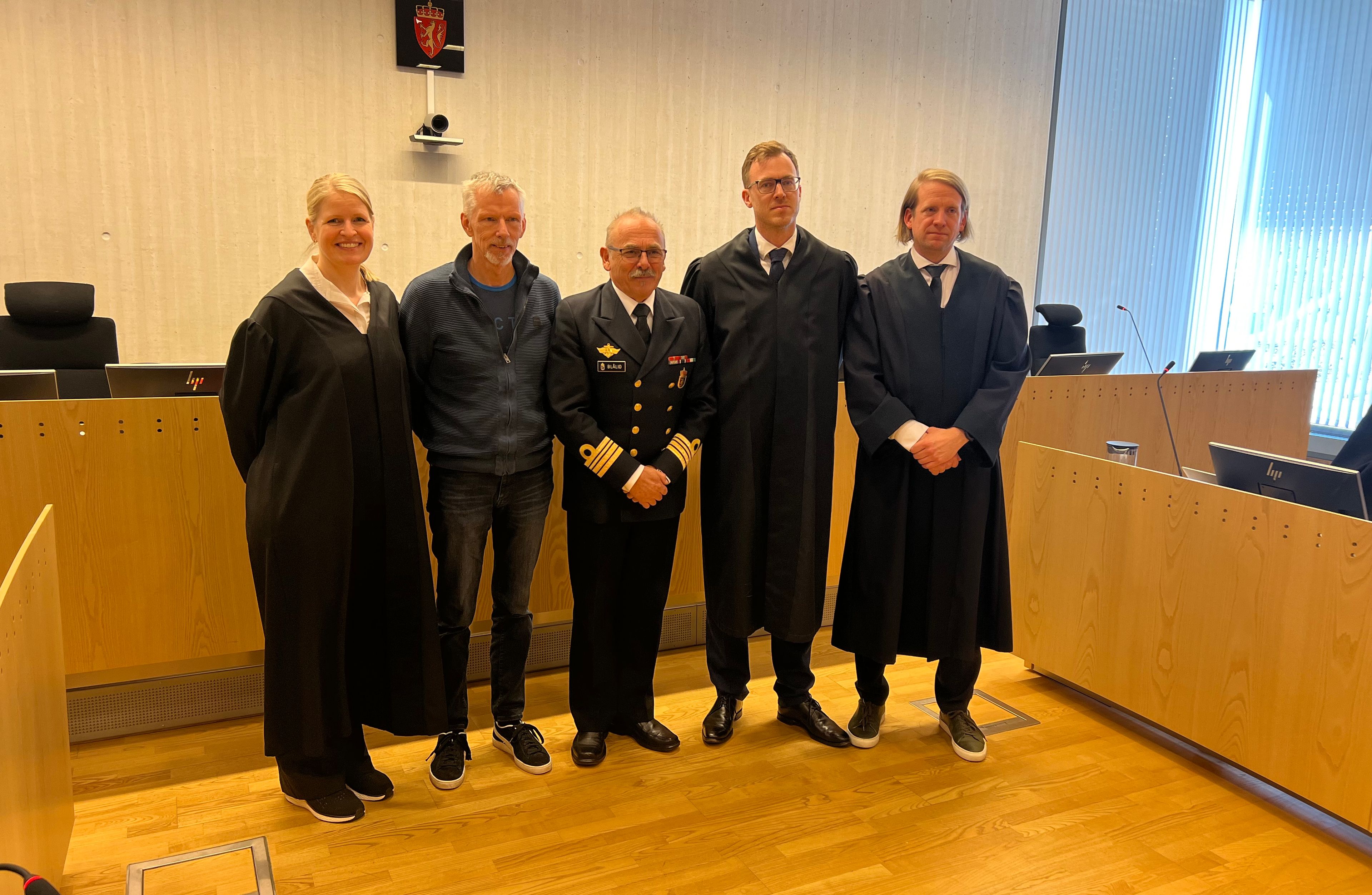 Bilde av personer i rettssal.