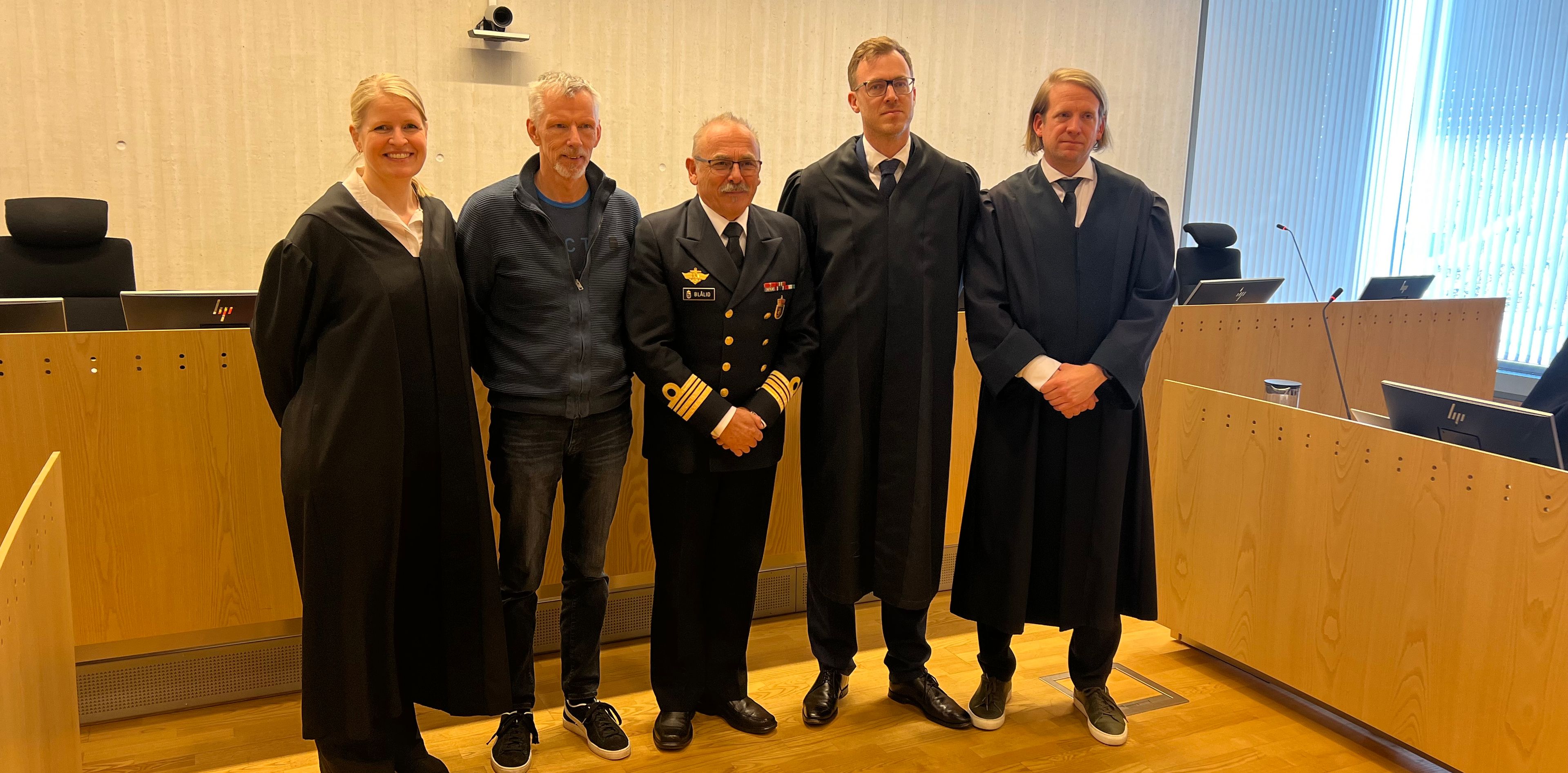 Bilde av personer i rettssal.