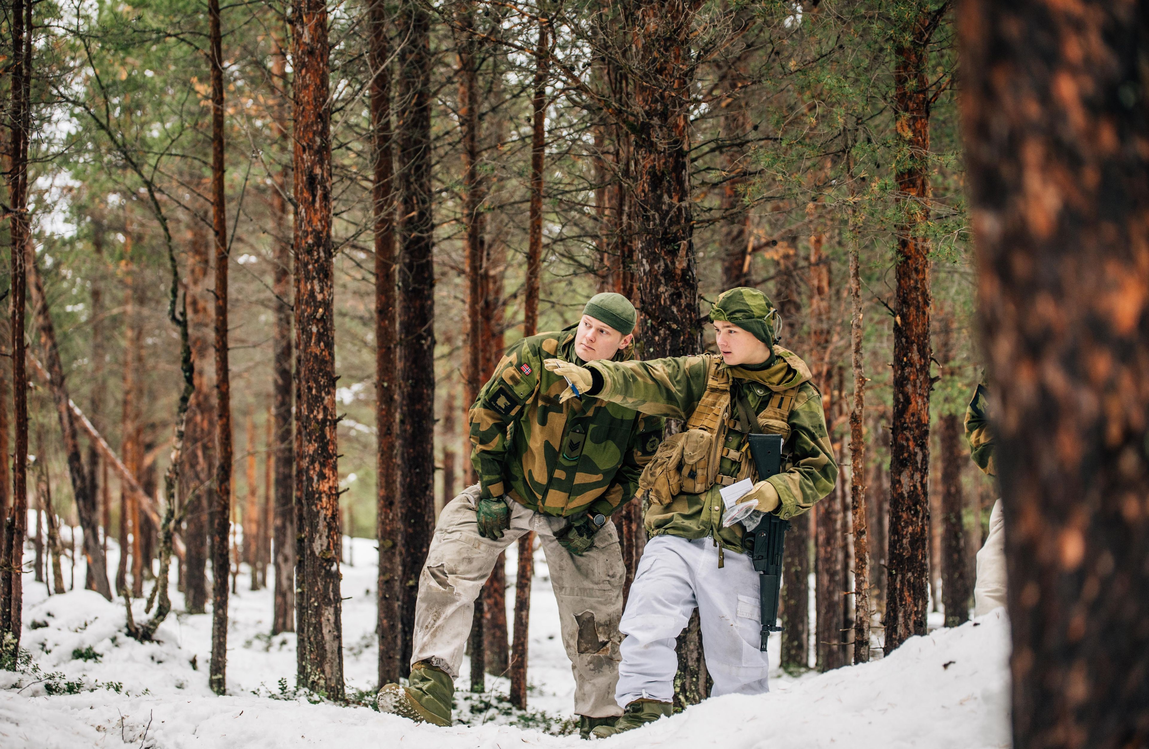 To personer i militæruniform i skogen