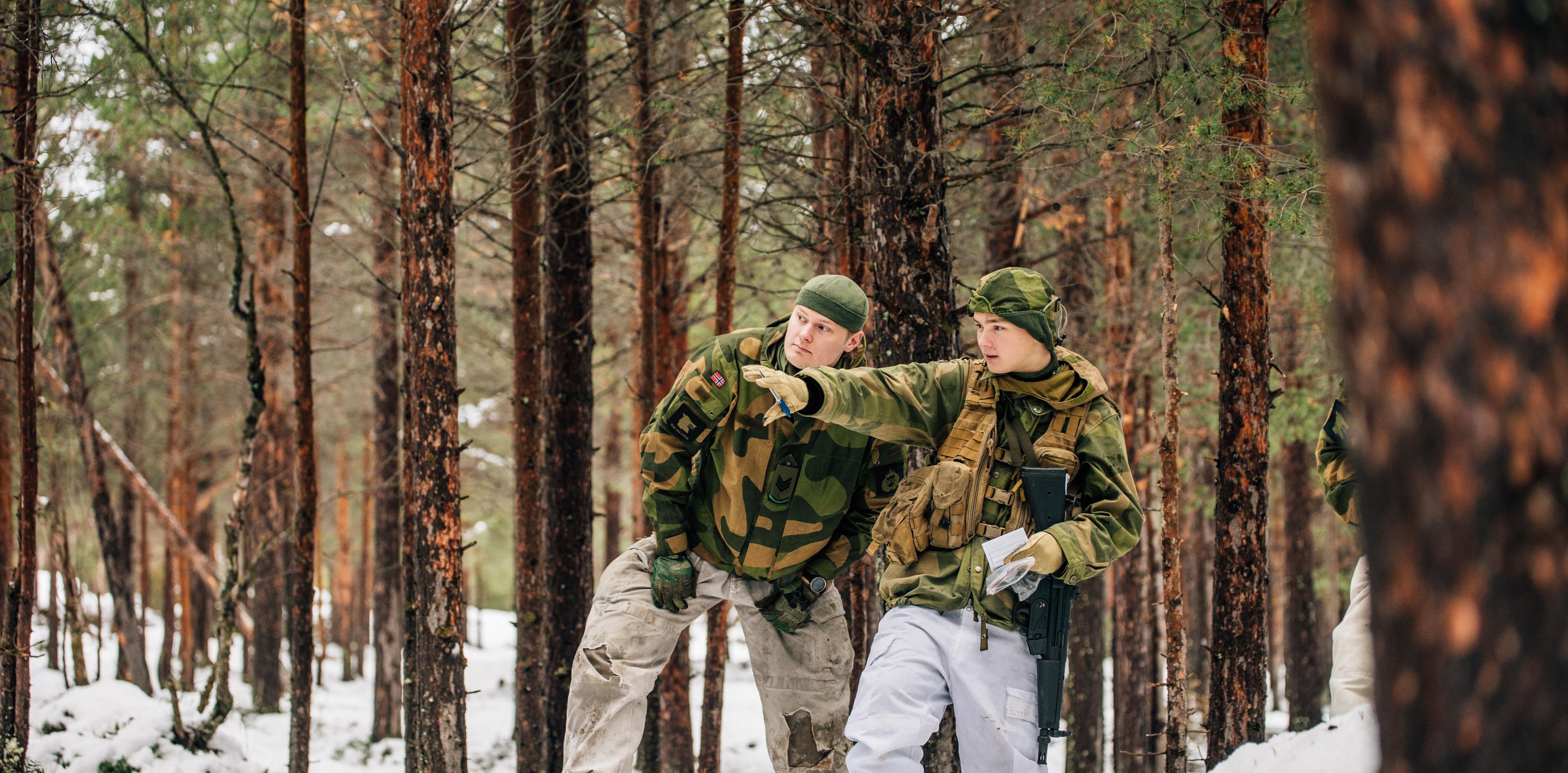 To personer i militæruniform i skogen