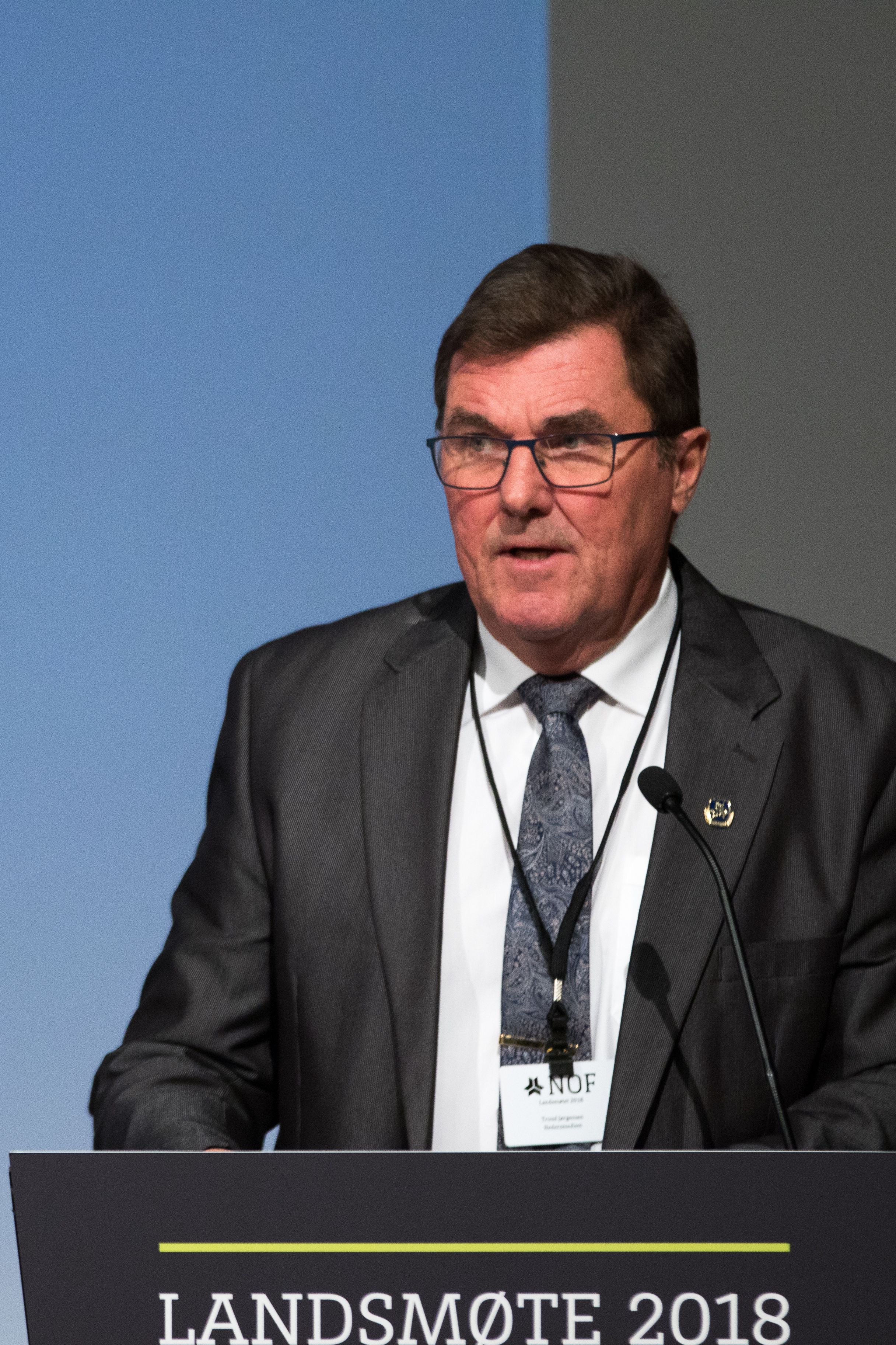 Eldre mann i dress på talerstolen