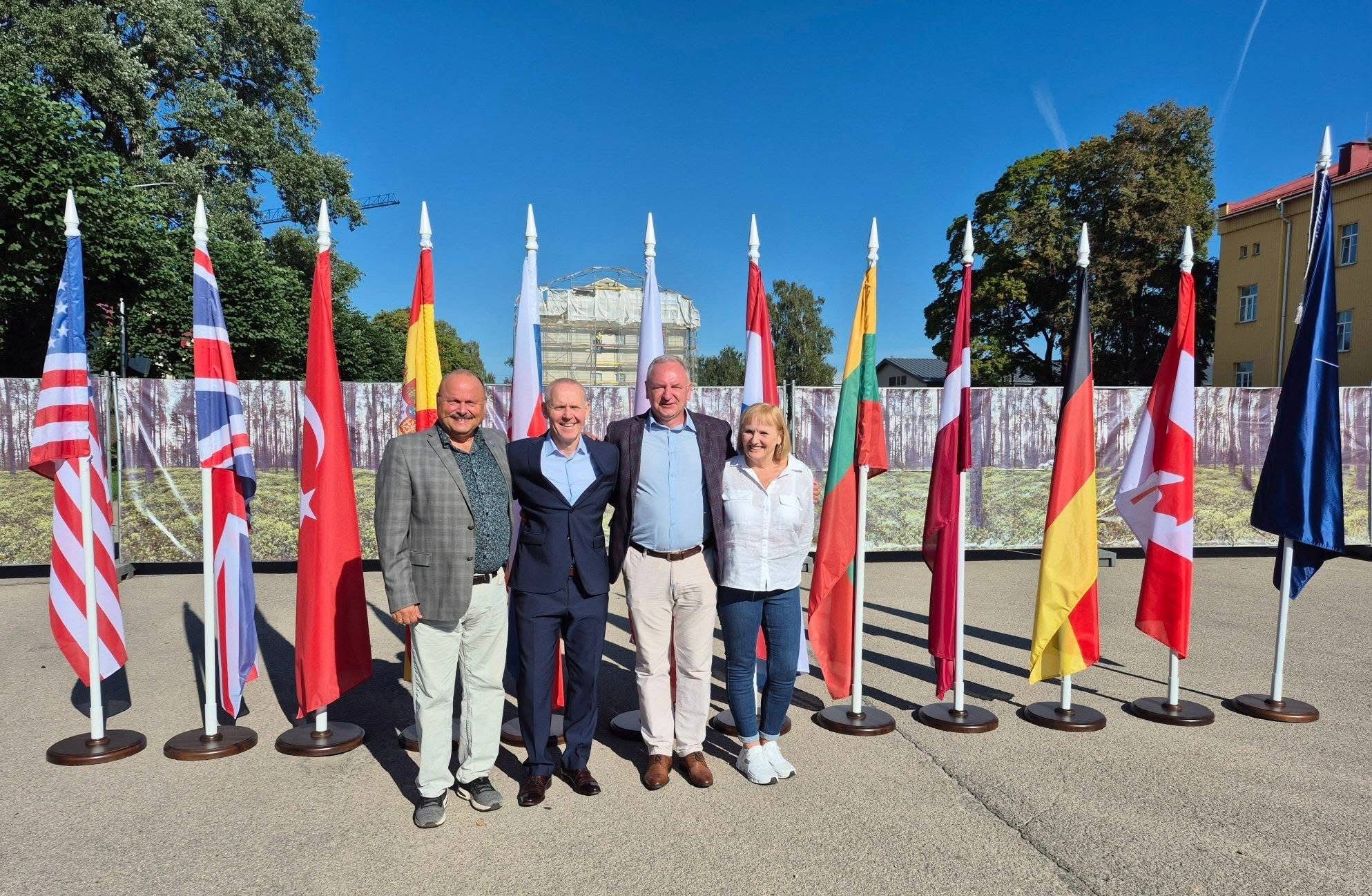 Foran flagg. Fra v. Major (P) Bjørn Vikås, Oberst Eriks Naglis NFIU 1.commander,  Oberst Janis Gailis NFIU 2.commander og Major (P) Beathe-Kristin Andestad. Fotograf:  Bjørn Vikås