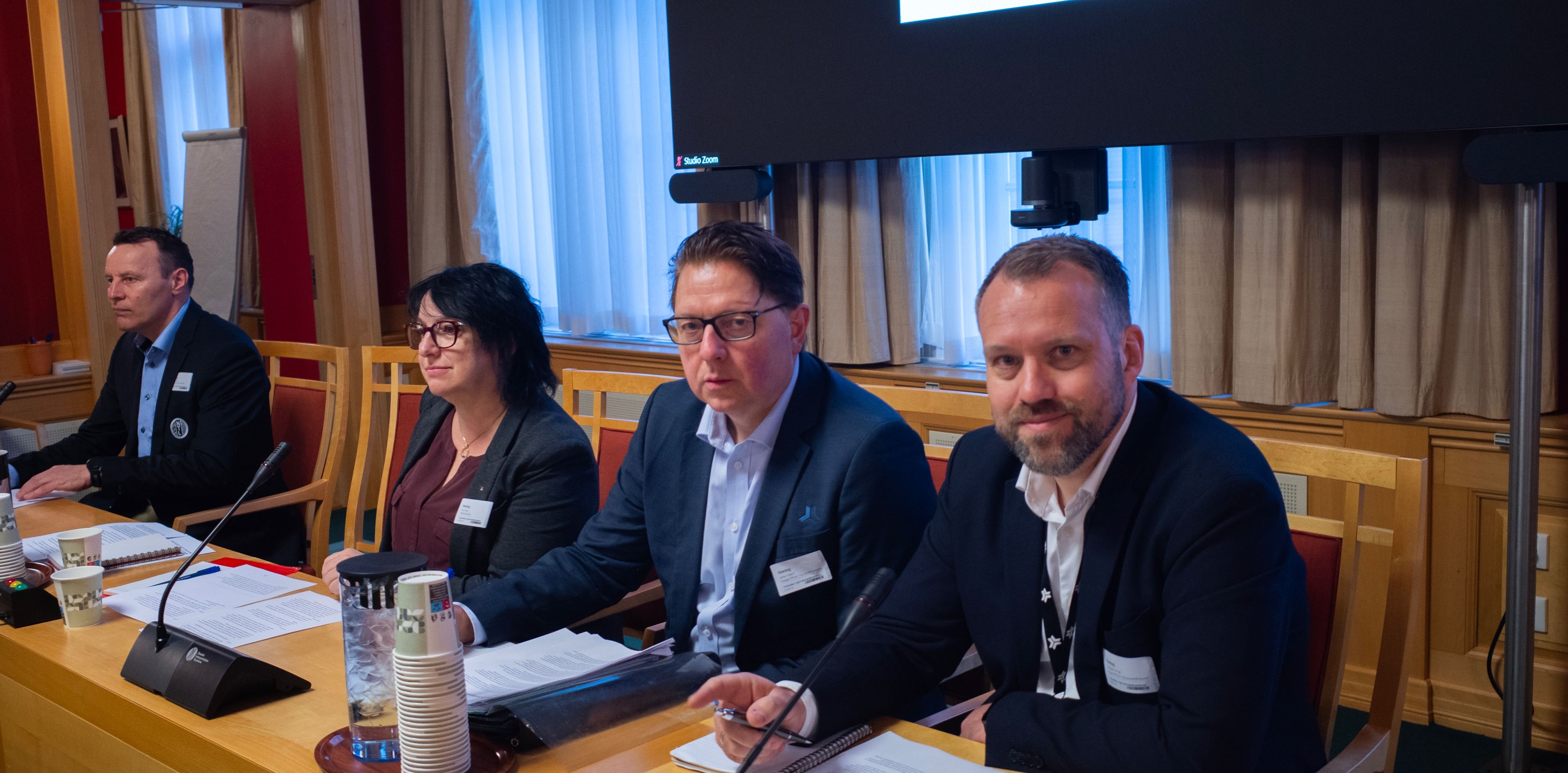 Sittende mennesker med sakspapirer.