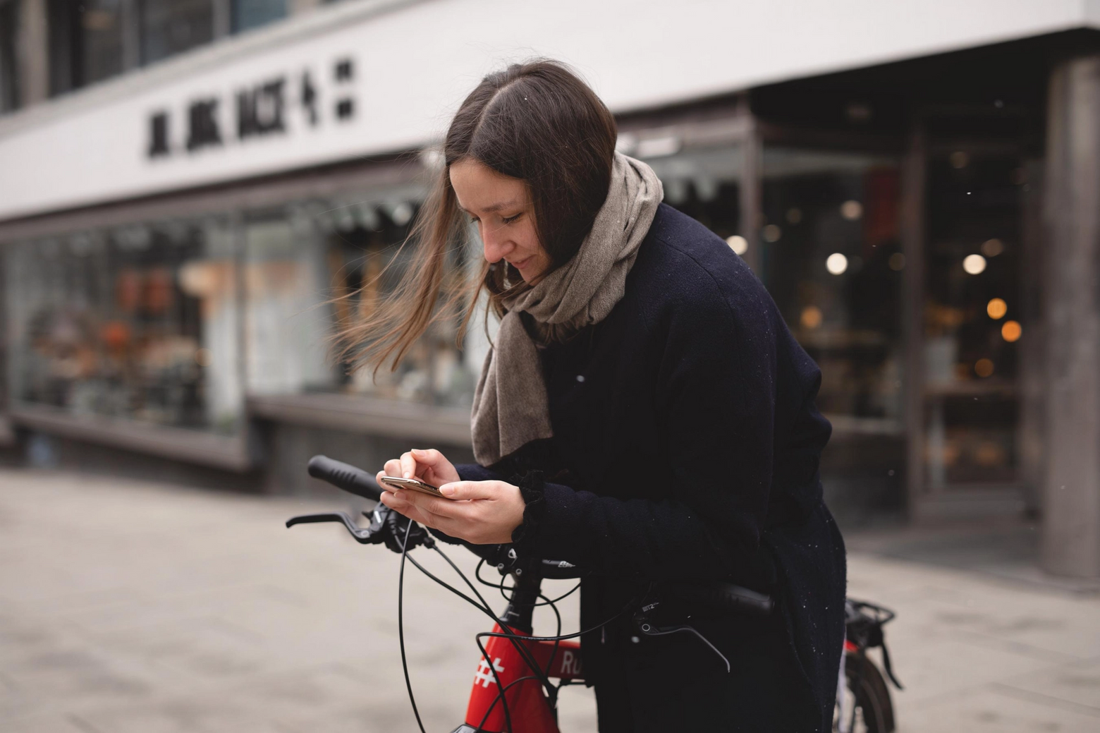 En dame med en Ruter-sykkel ser på mobilen