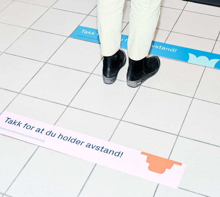 Gulvplakater som oppfordrer til å holde avstand, i Lillestrøm kommune sin nye profil