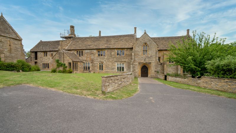 Stone manor house exterior surrounded by lush gardens