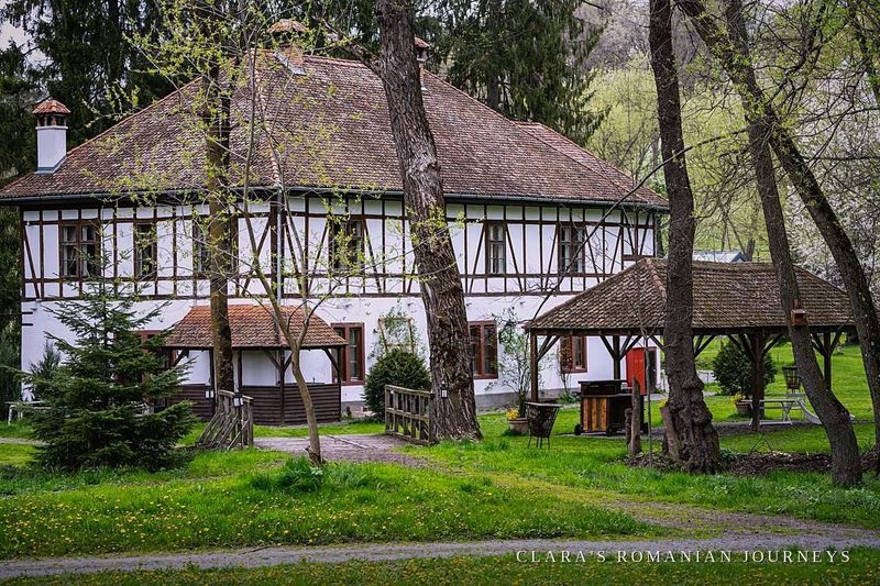 Half-timbered estate outbuilding with a wooden gazebo in the garden