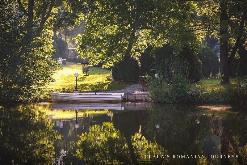 A white wooden rowing boat moored on the estate's lake at dusk