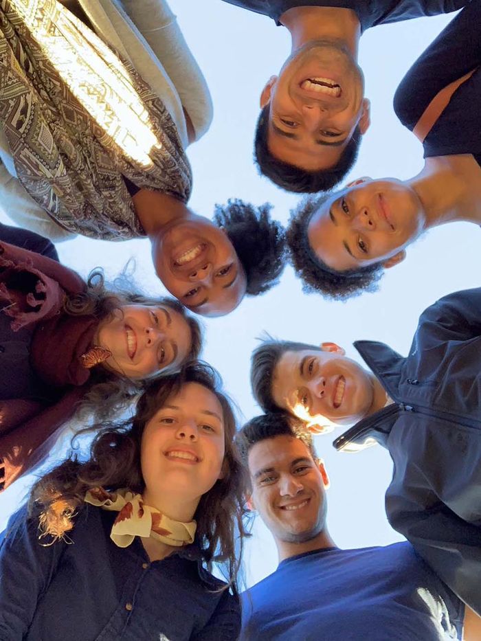 A group of young people looking down into the camera, smiling