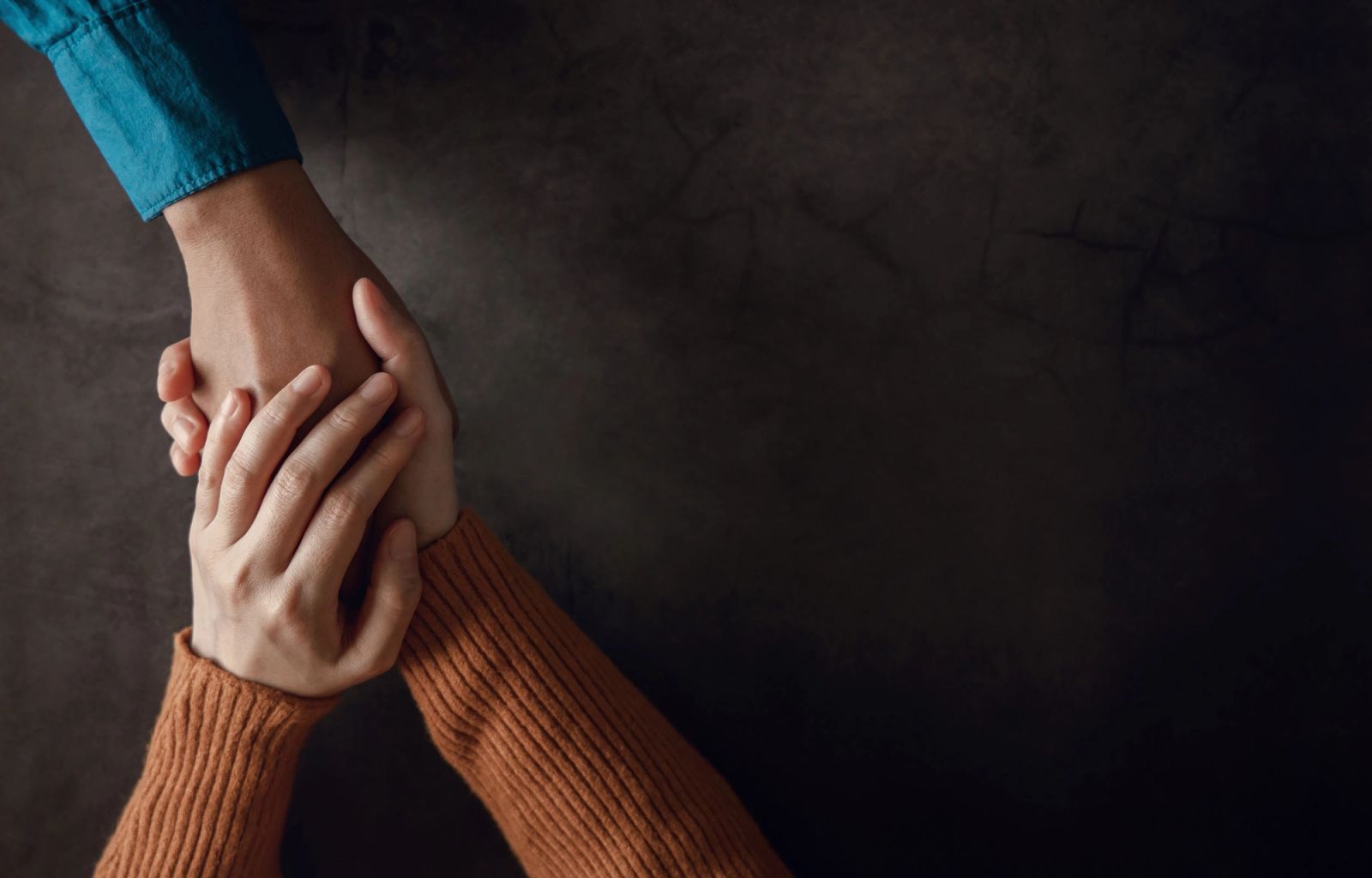 Two people holding hands in support