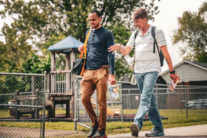 Two men walking and talking outdoors