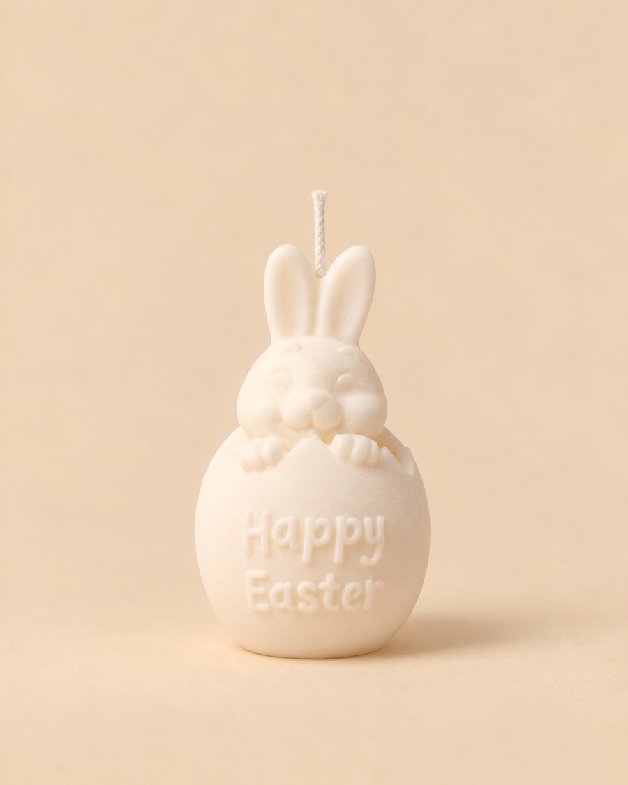 Vela em forma de ovo de Páscoa com orelhas de coelho e a mensagem Happy Easter