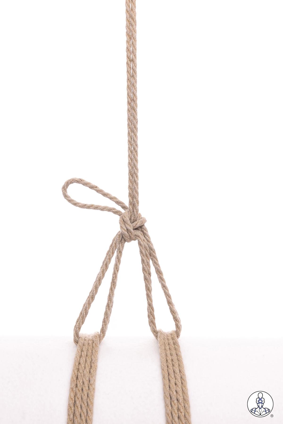 Natural jute rope showing a basic overhand knot with a single loop formed above the knot, with multiple rope strands hanging below against a white background.