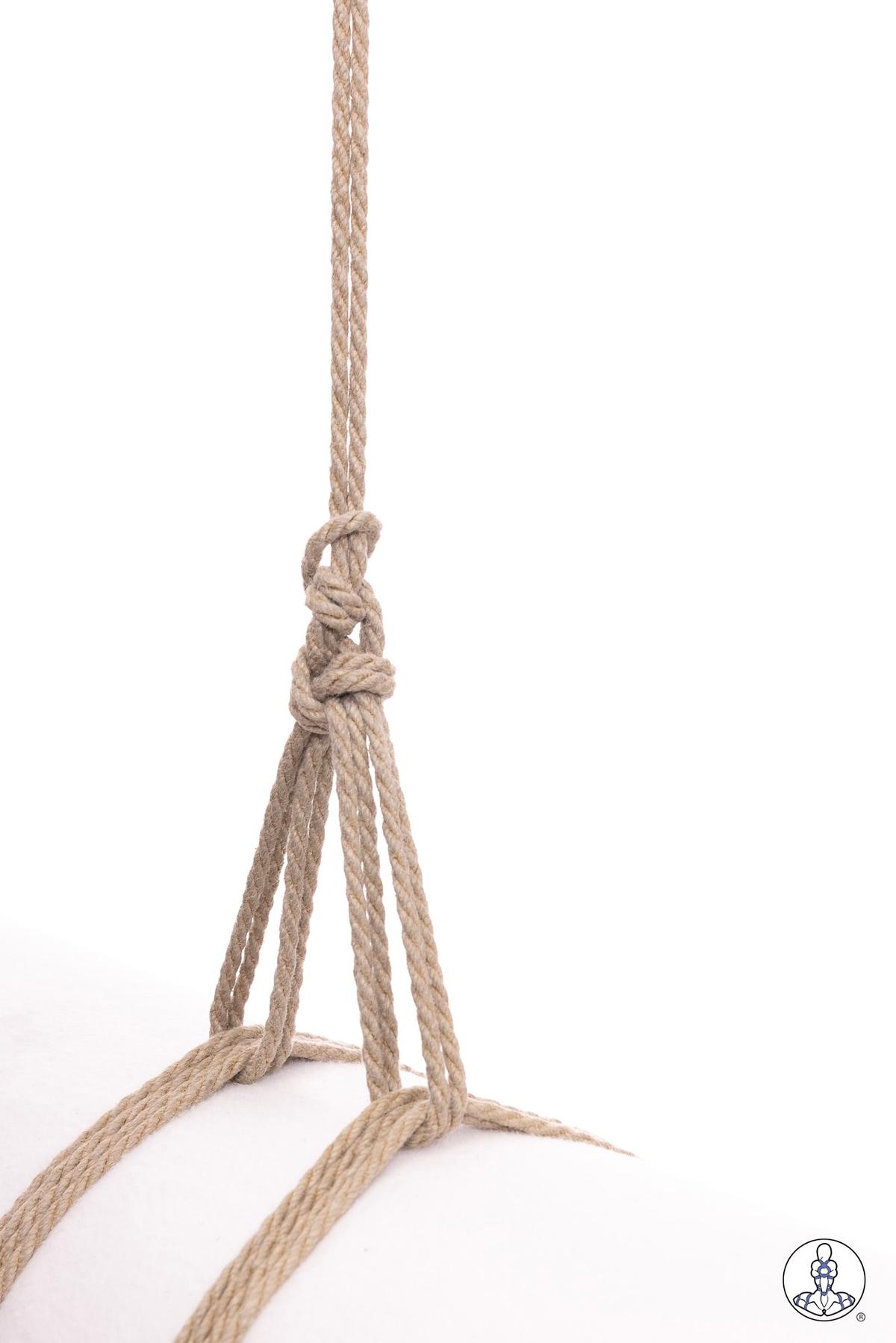 Natural jute rope gathered and knotted together showing a gathering knot technique with four strands hanging below and one strand extending upward, displayed against white background.