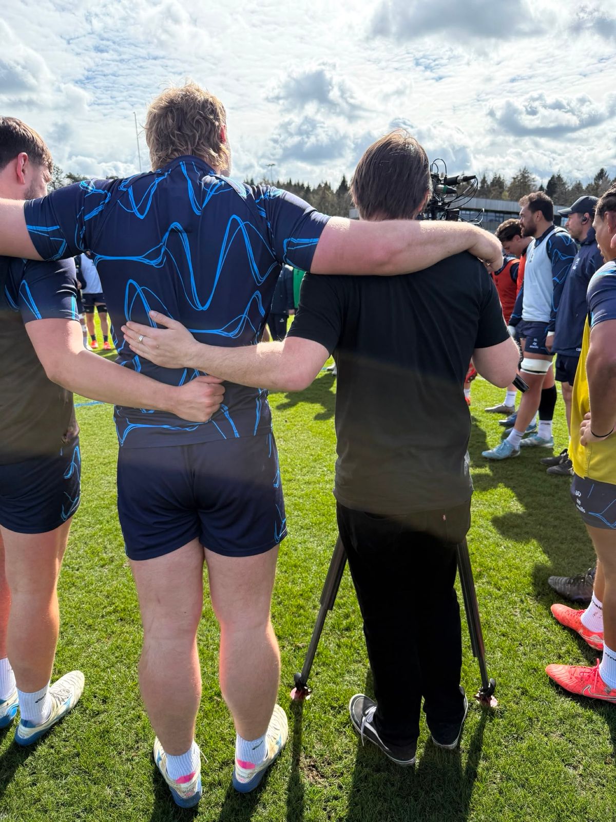 Charlie arm in arm with Bristol Bears players in a training huddle