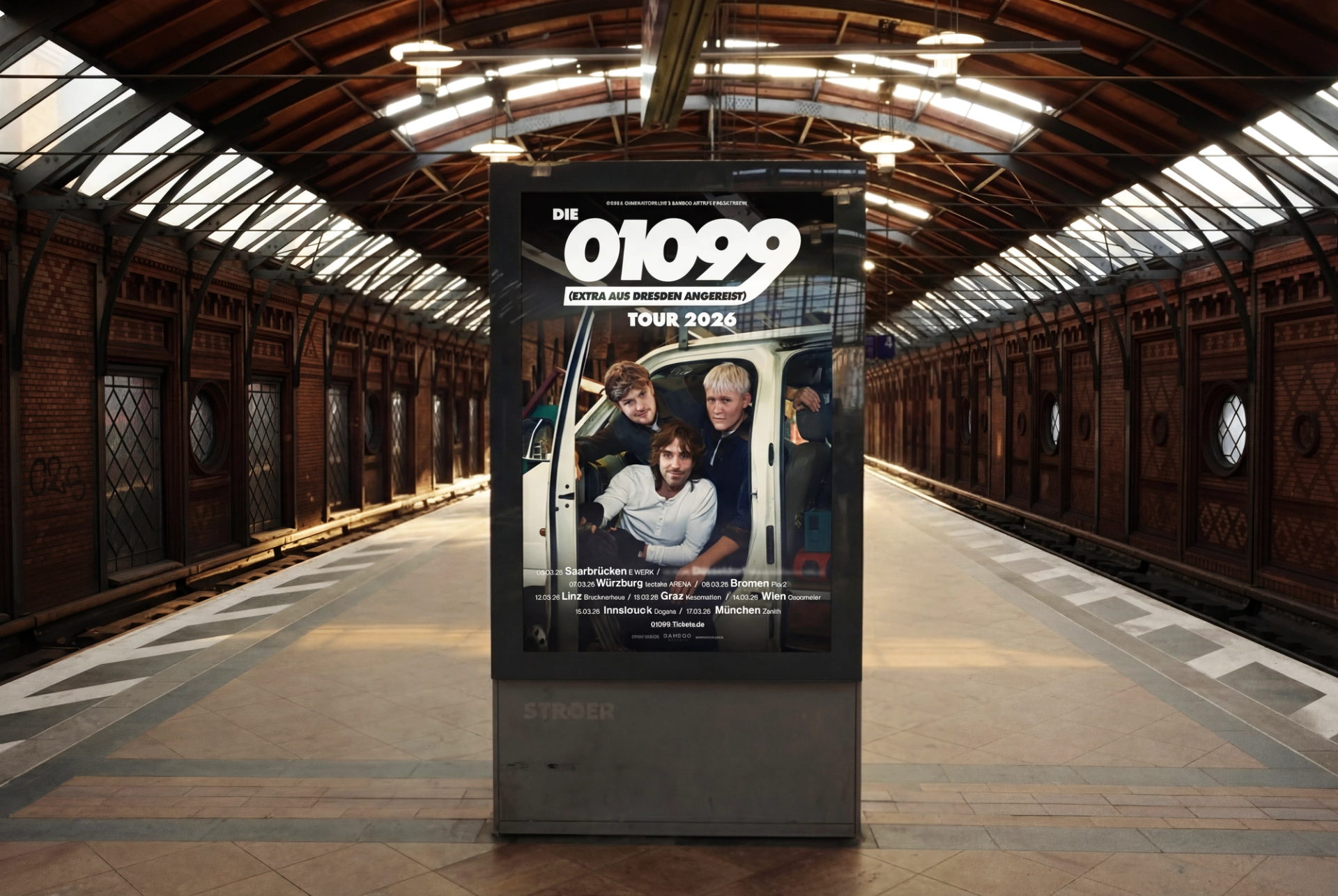The 2026 tour poster in an advertising display on a station platform under a wooden roof.