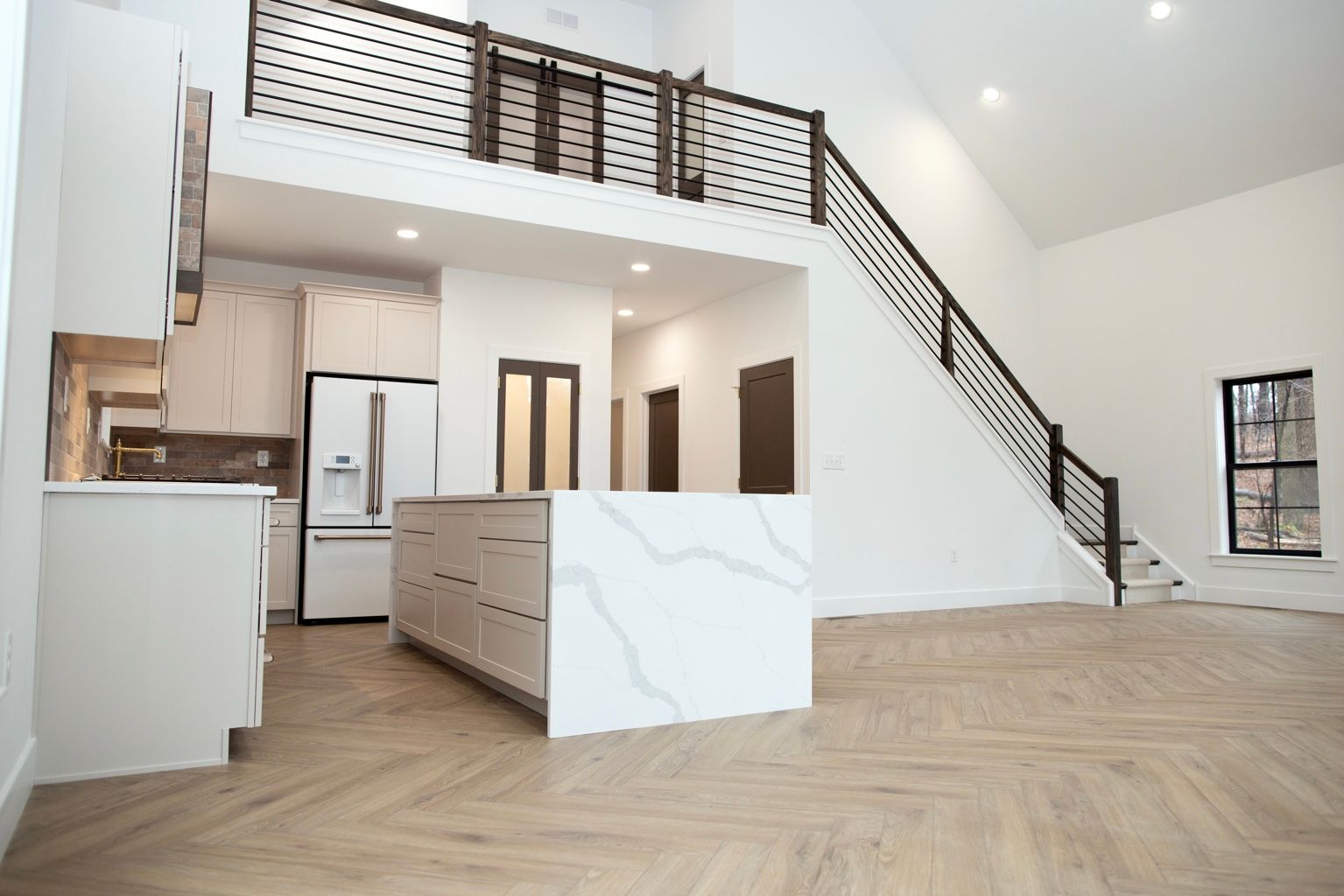 Completed custom home interior with a loft, staircase, and kitchen