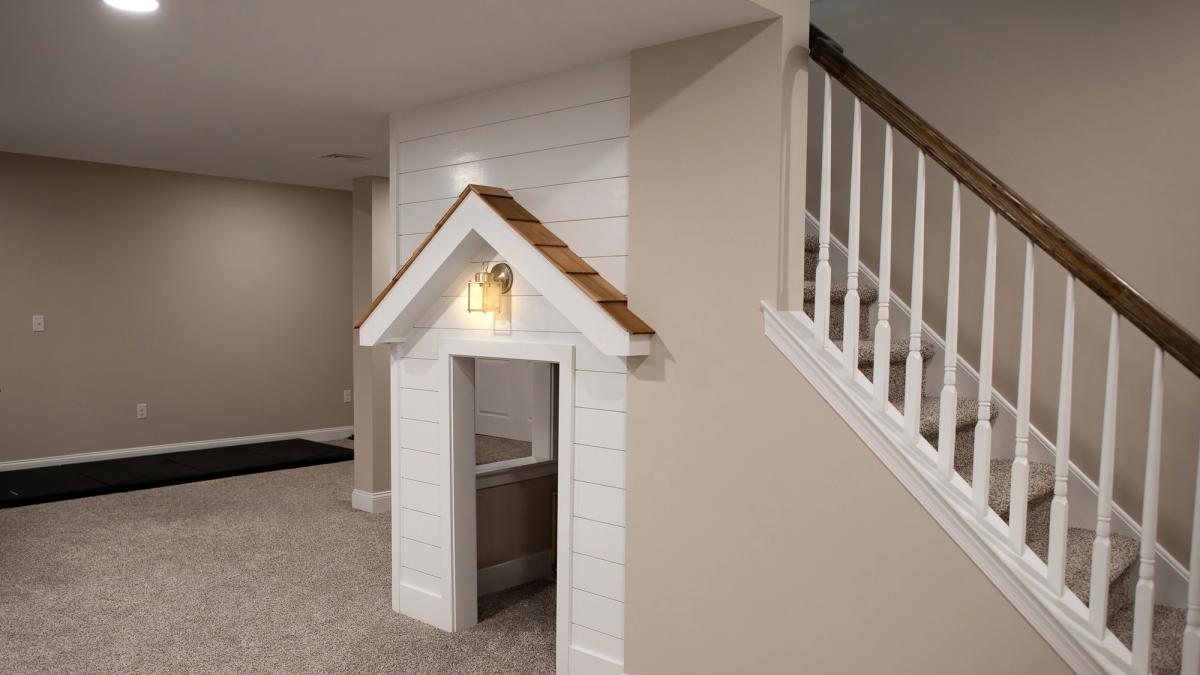 A photo of a modern finished basement with custom playhouse