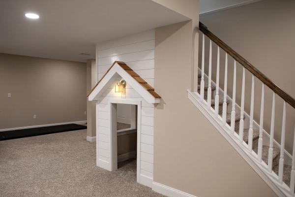 A photo of a modern finished basement with custom playhouse