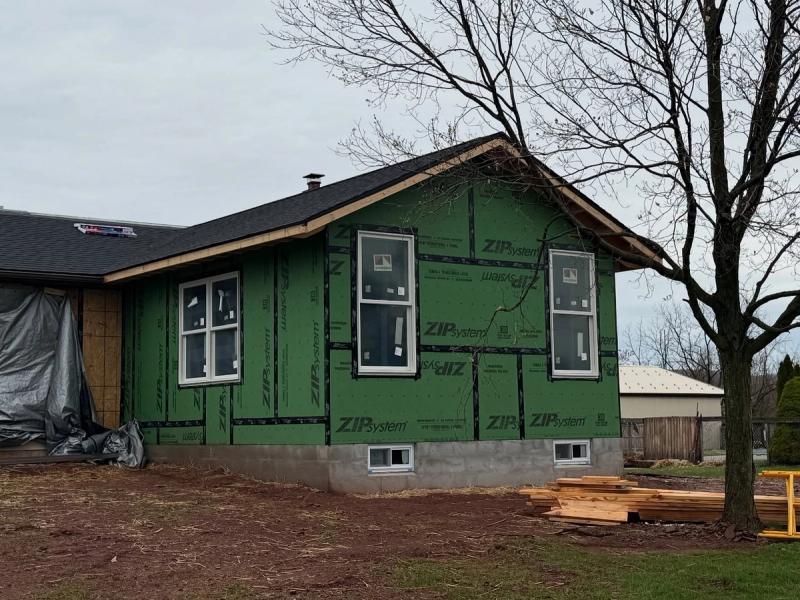 Photo of exterior of house with new walls awaiting siding